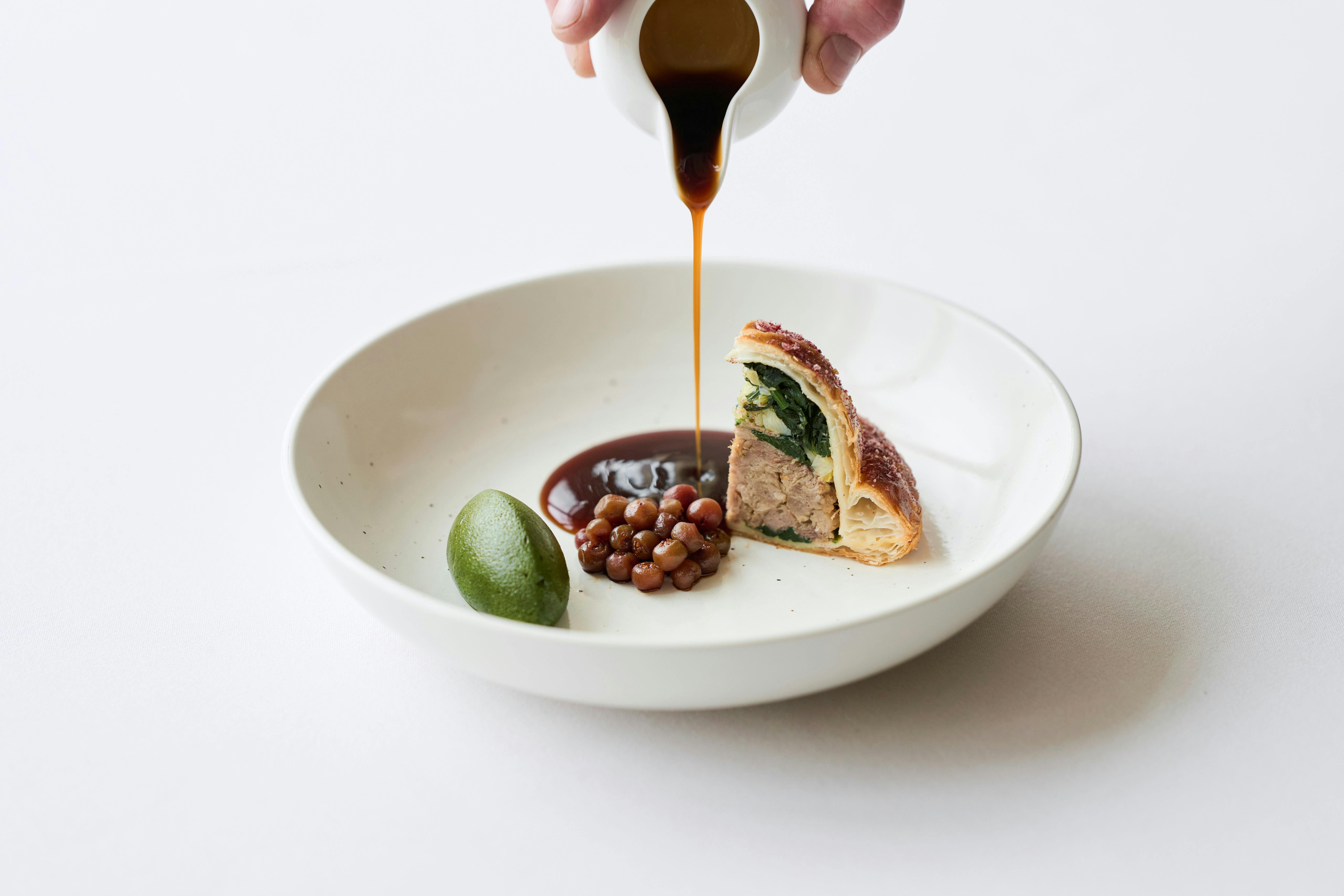 Sauce being poured over a meal.