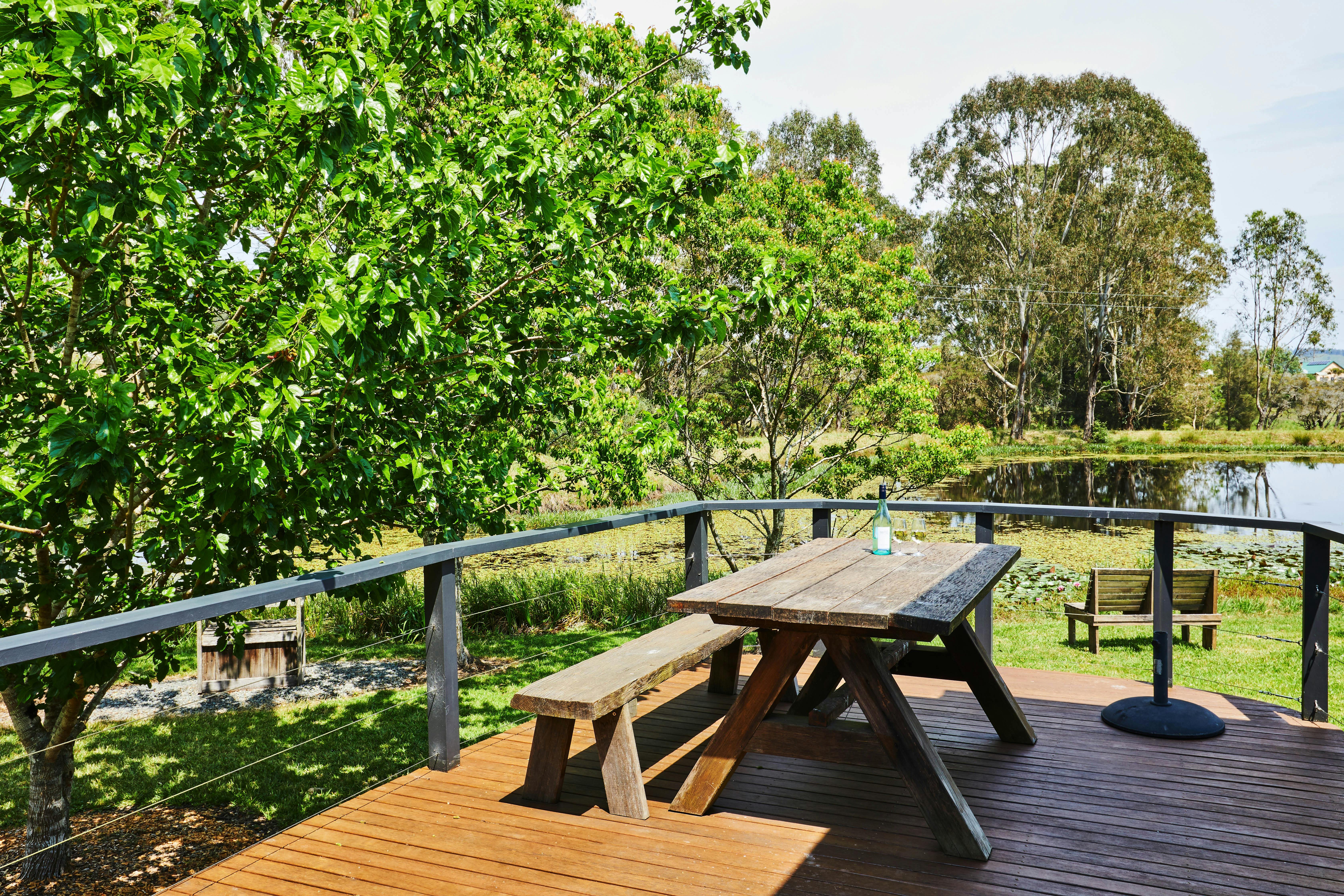 Outdoor wooden deck with table & bench, over looking the peaceful dam with abundant birdlife.