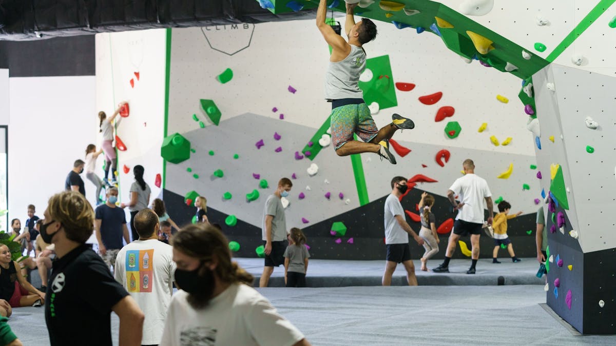 Bould Move - Boulderer on Prow with people watching