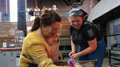 teacher and participant blowing glass in the Hotshop