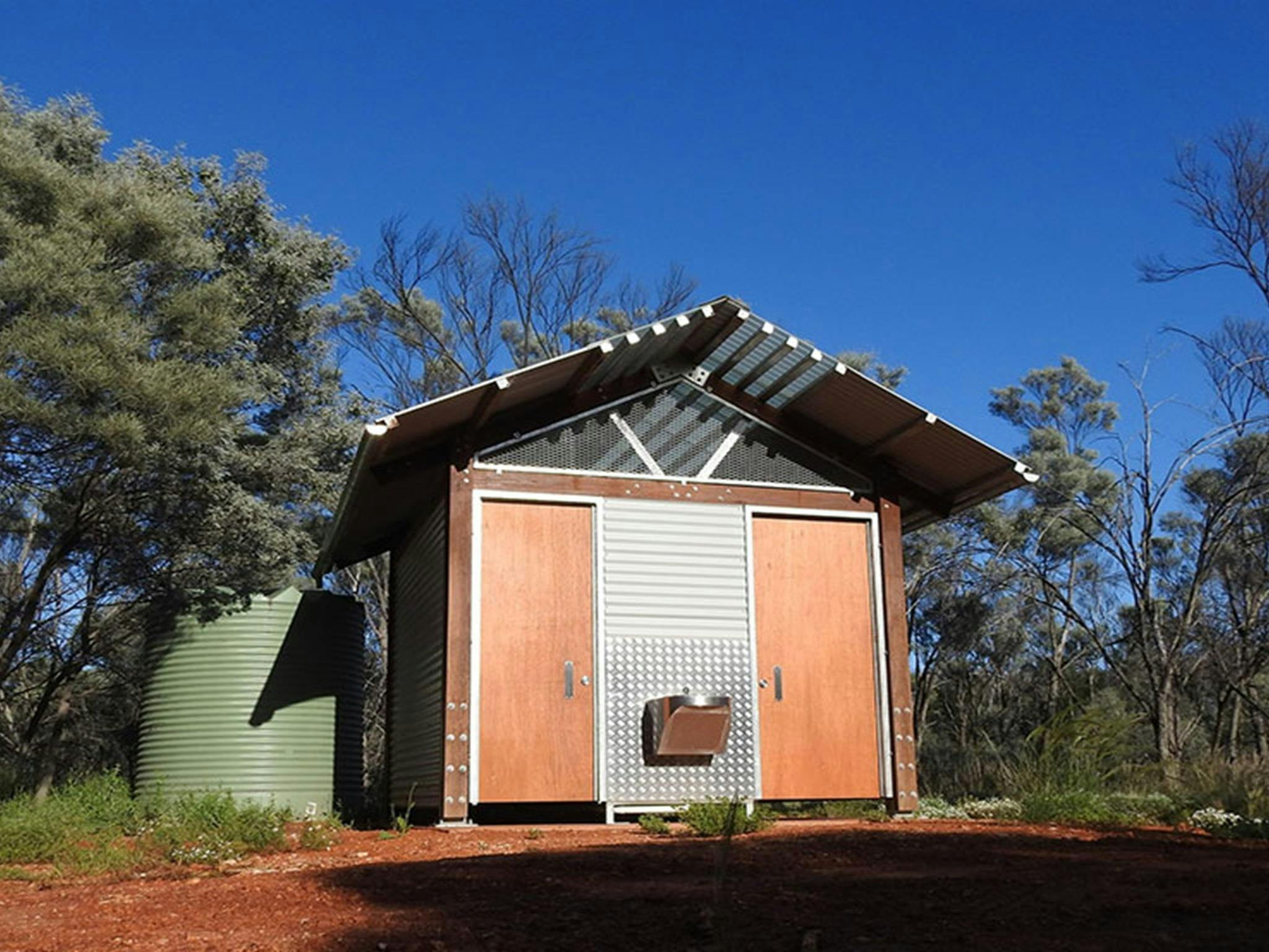 Foto der Toilettenhütte und des Waschbeckens, umgeben von Bäumen, auf dem Campingplatz und Picknickplatz Dry Tank in