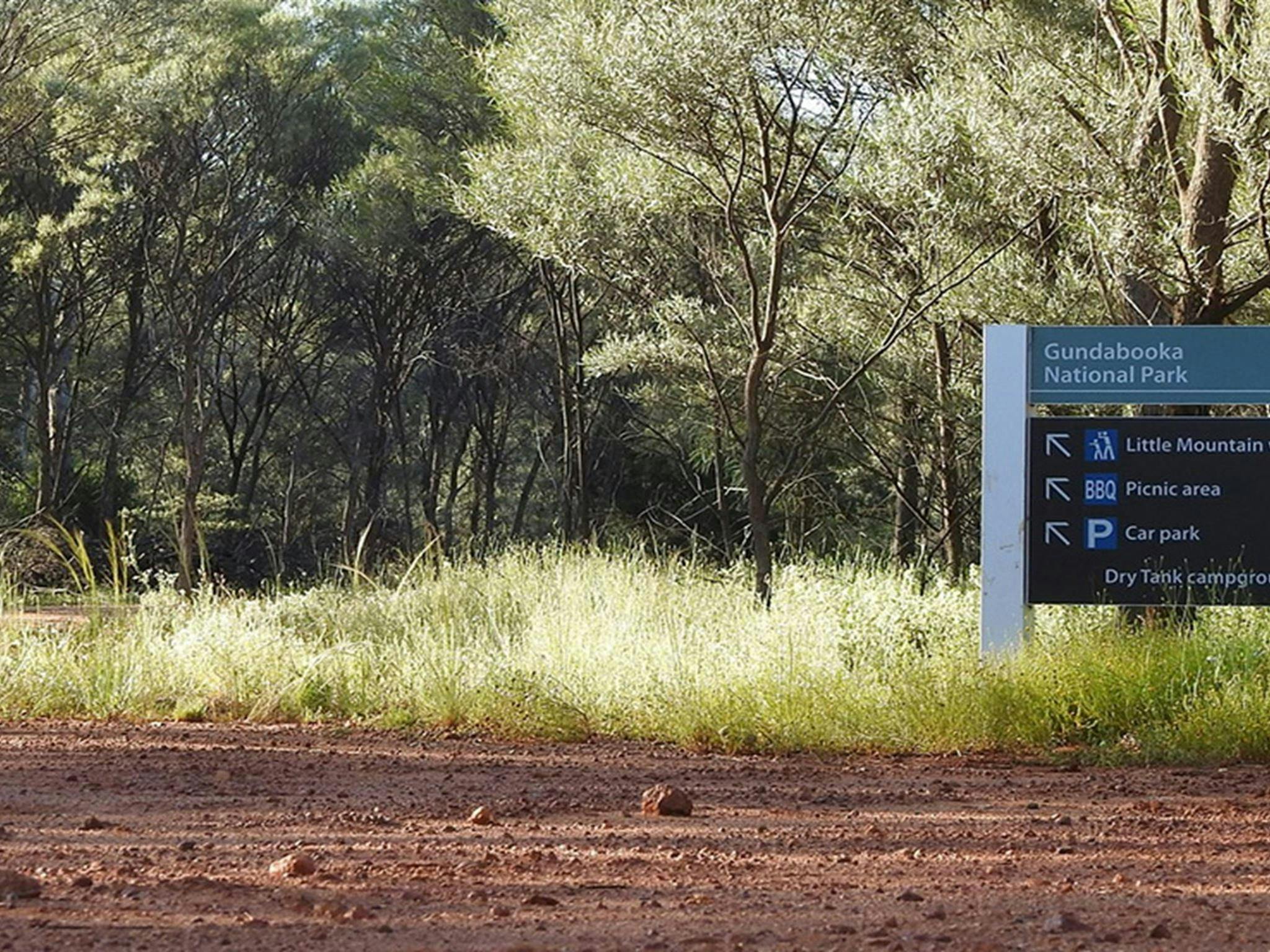 Photo of a sign on a red dirt road pointing to Dry Tank campground and picnic area at Gundabooka