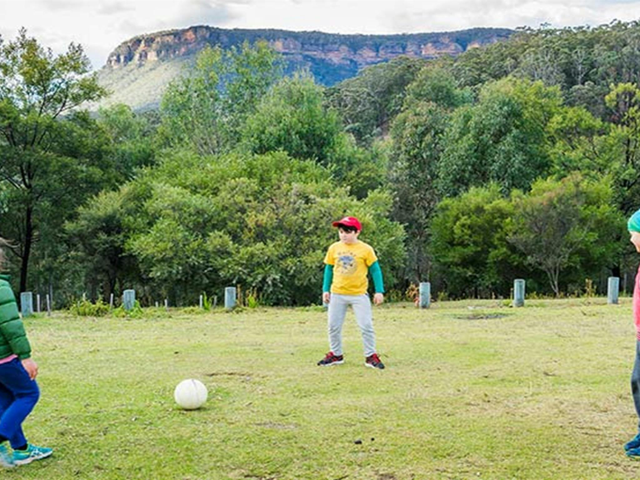 Drei Kinder spielen Fußball auf dem Campingplatz Dunphys im Blue Mountains Nationalpark. Foto: Simone