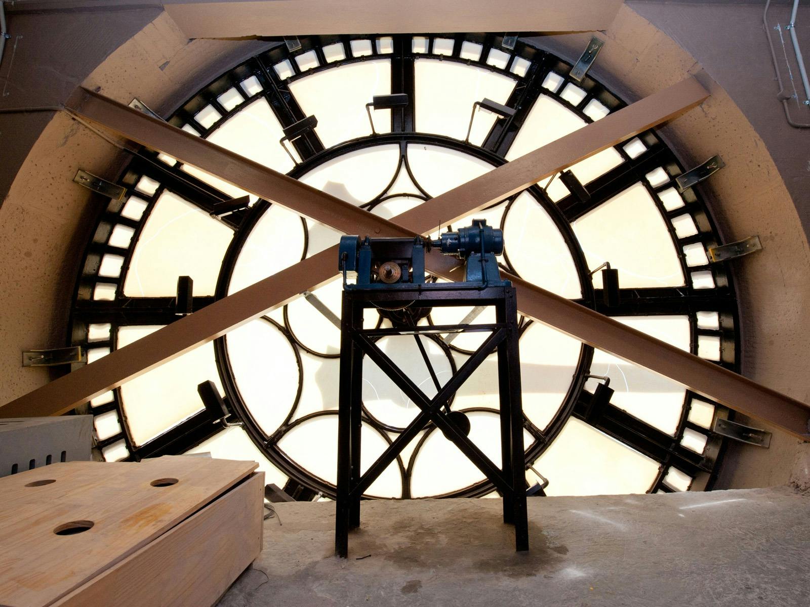 Looking through a large clock face from inside a clock tower.