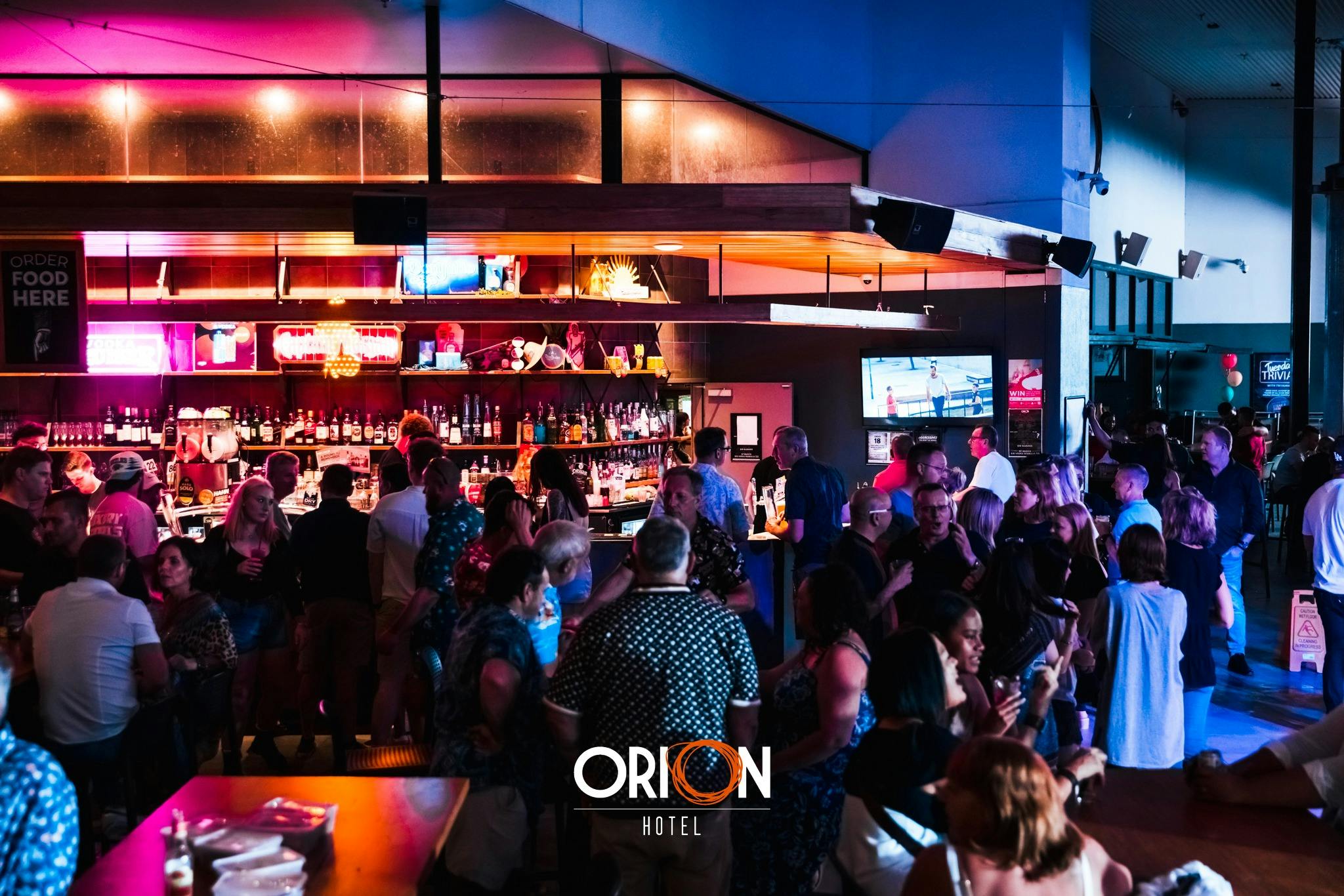 Crowd of people talking and lining up at the bar at Orion Hotel Springfield