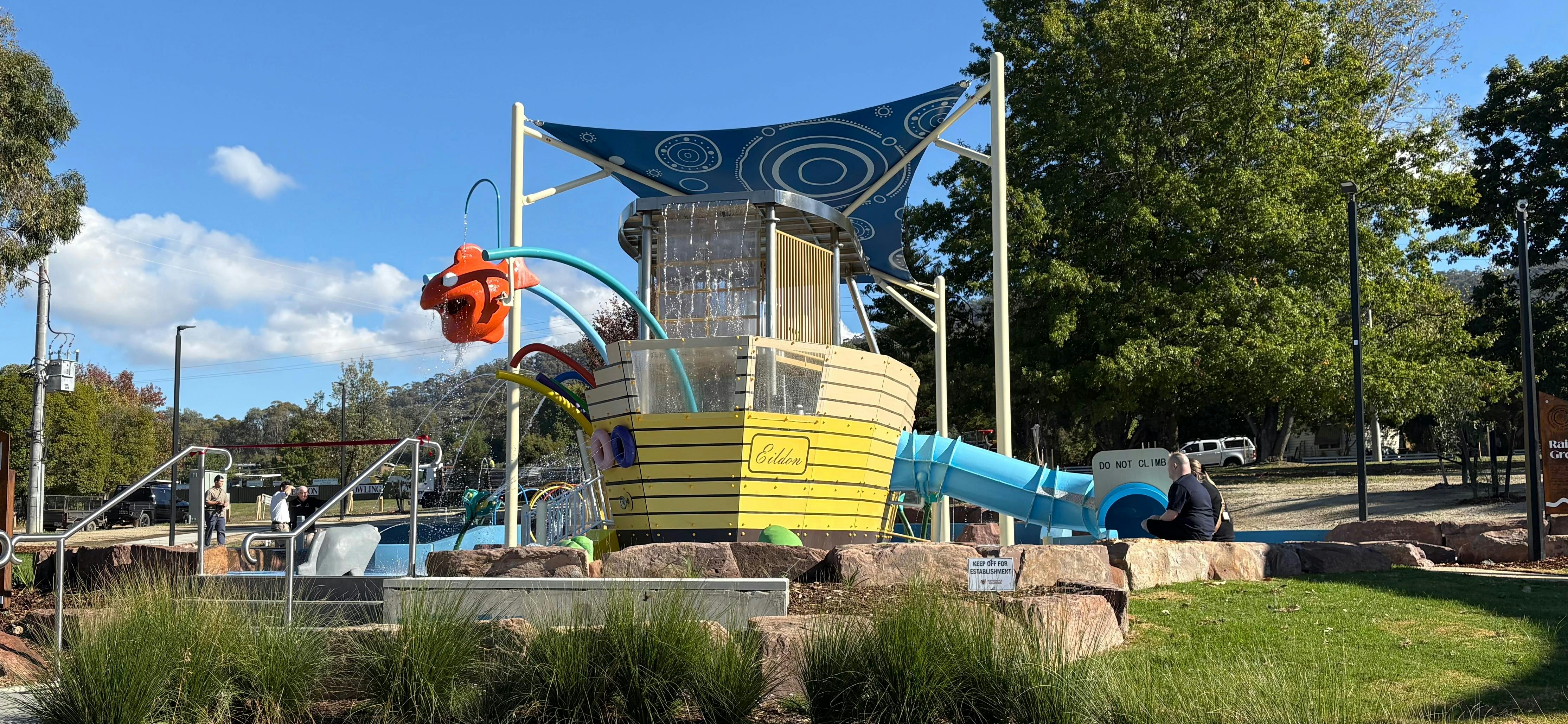 a large ship structure with water slides and sprinklers with a tarp over it