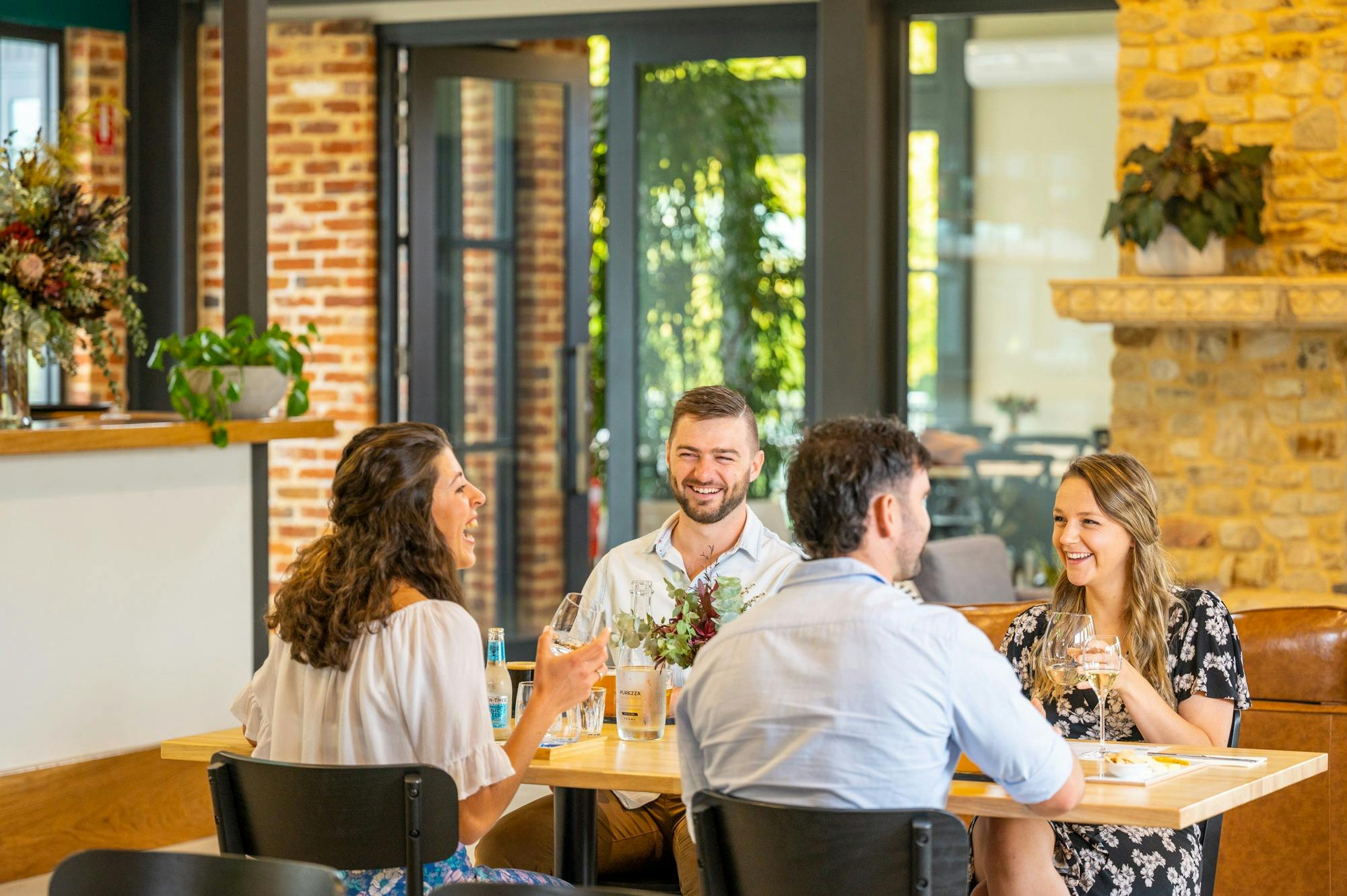4 people sitting at a table laughing