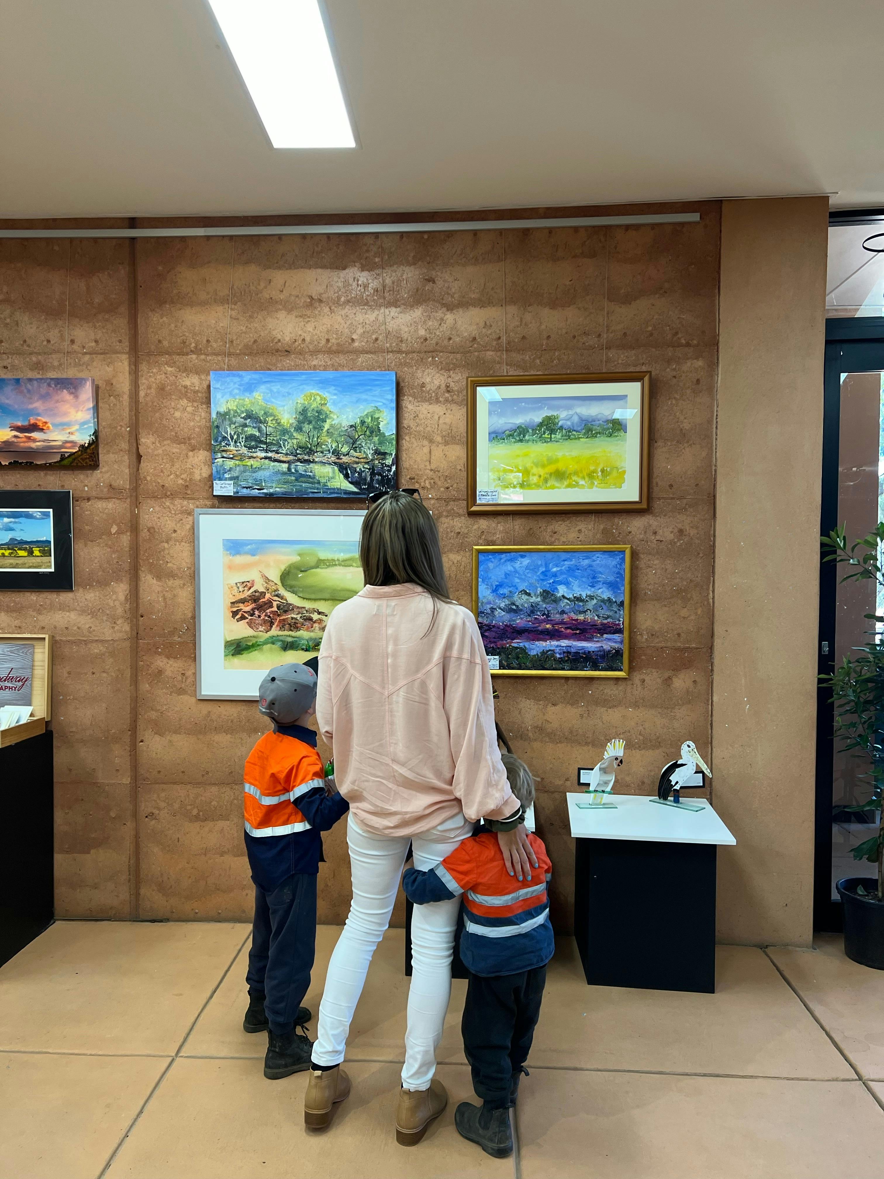 Young family admiring some artwork on display.
