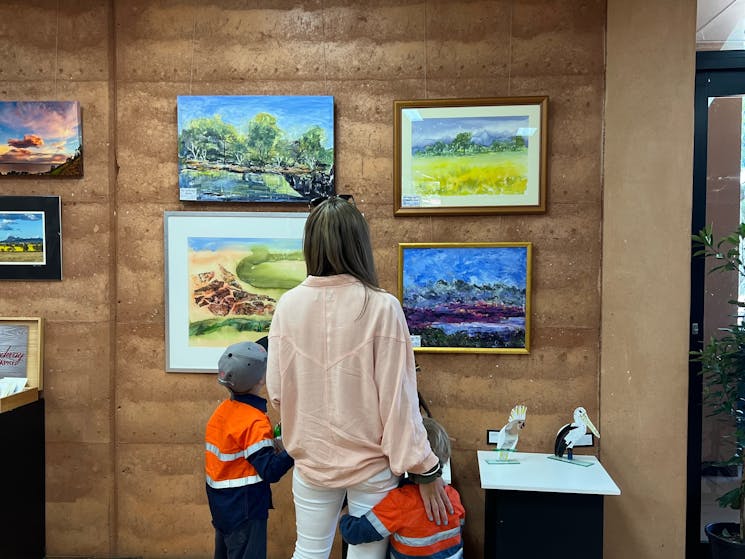 Young family admiring some artwork on display.