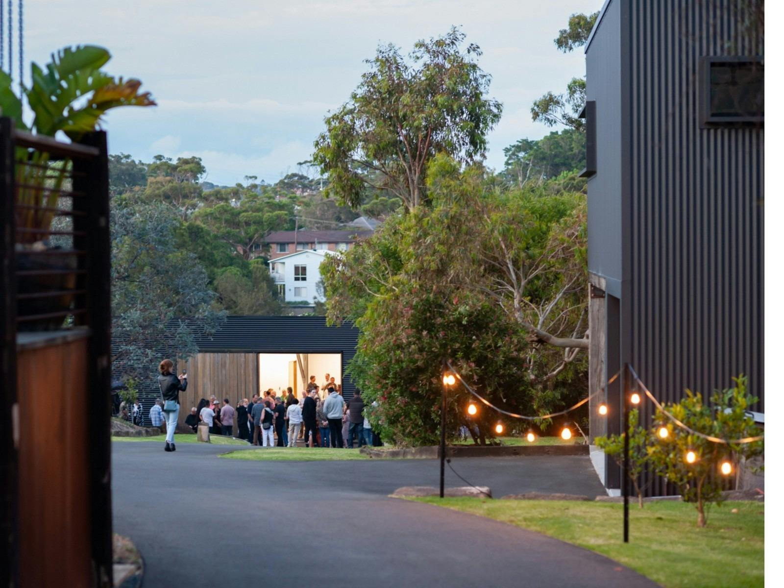 Picture of the Side of Building with pathway, grass and large tree next to building.