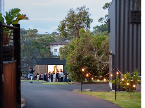 Picture of the Side of Building with pathway, grass and large tree next to building.