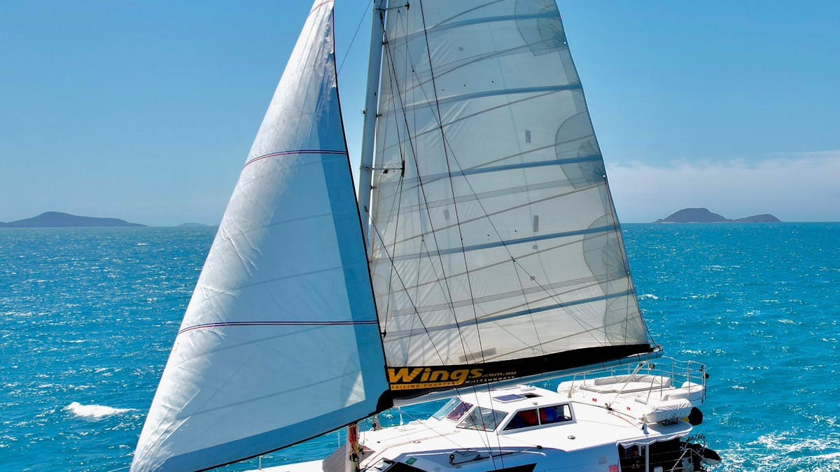 Wings III 60ft sailing catamaran under full sail on the water