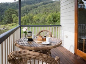 Casuarina - verandah table set for breakfast looking out to macadamia orchard