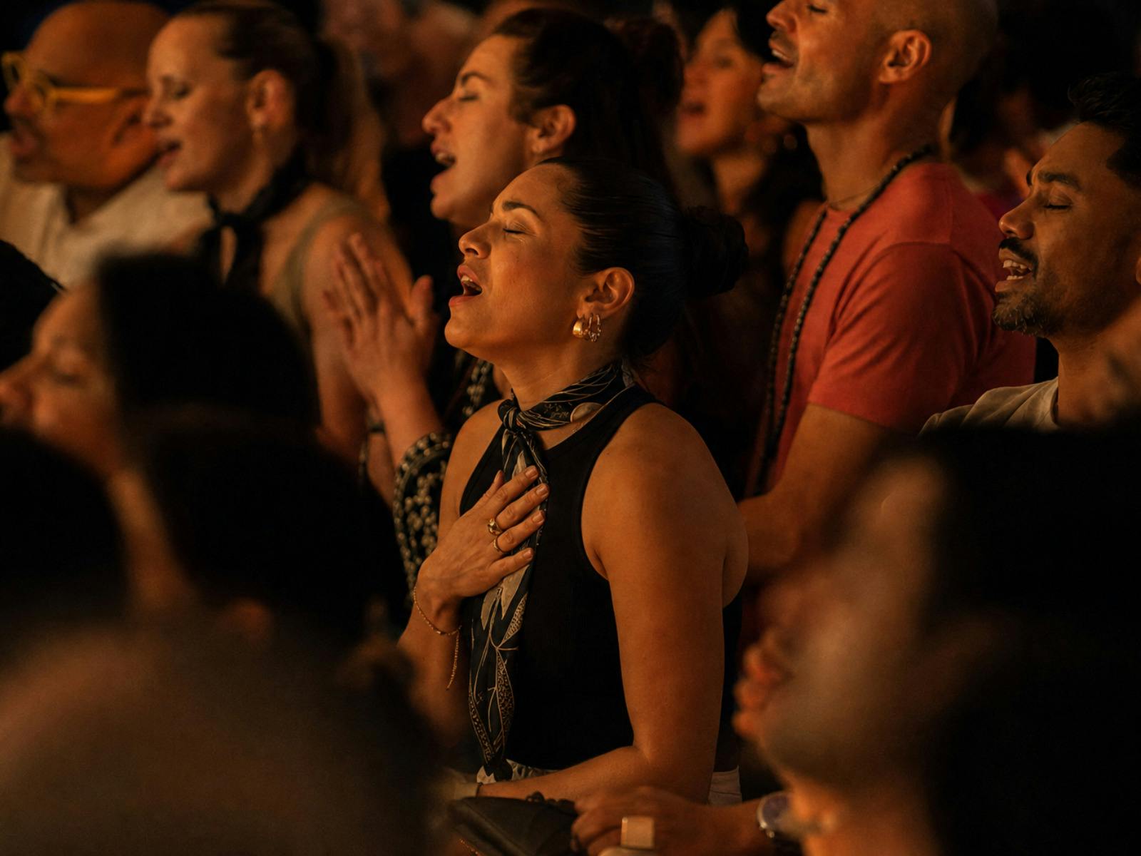 woman with hand to heart, singing