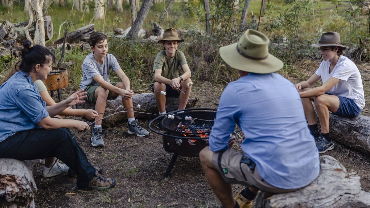 Family spending quality time together around the campfire, roasting marshmallows at Traveller's Rest