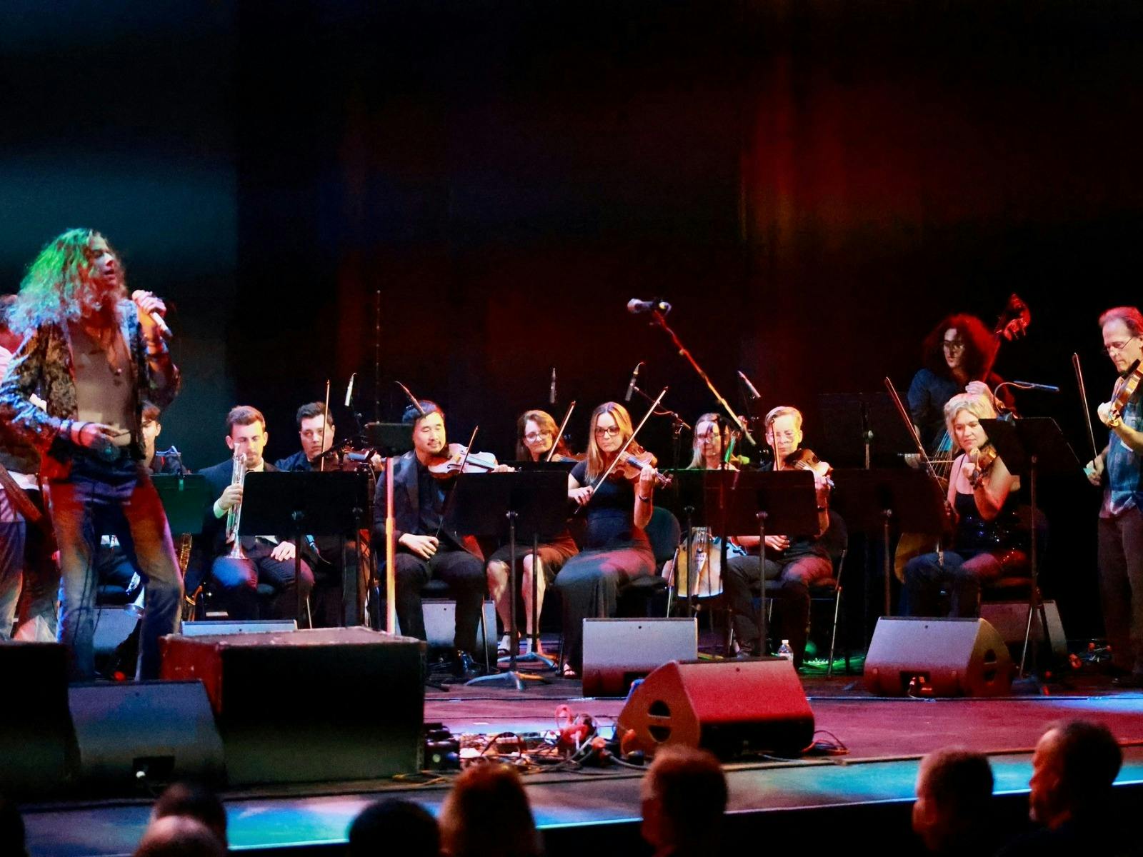 a band on stage with an orchestra