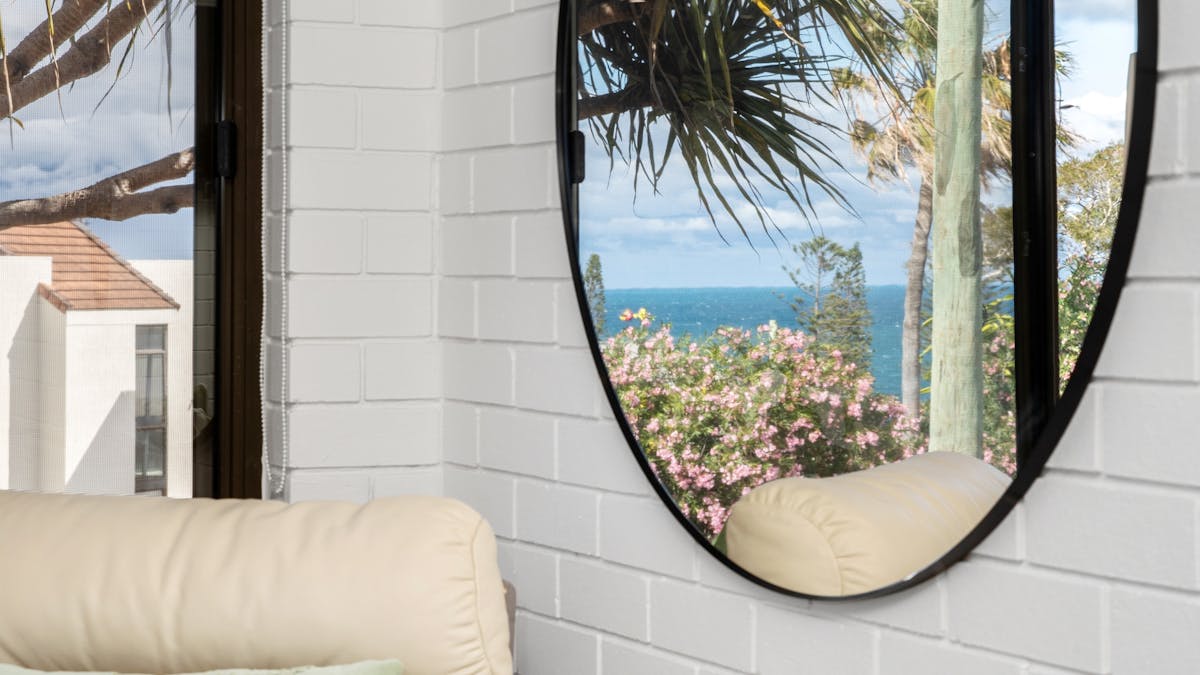 close up circular mirror, leather couch