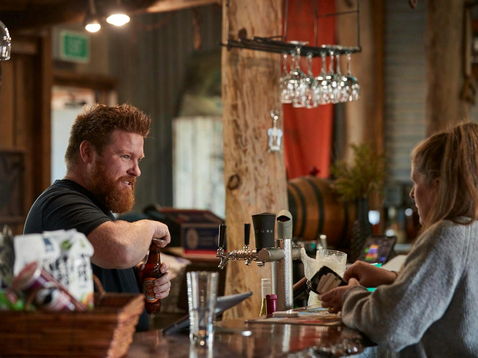 Barney's owner Damon serving a customer at the bar