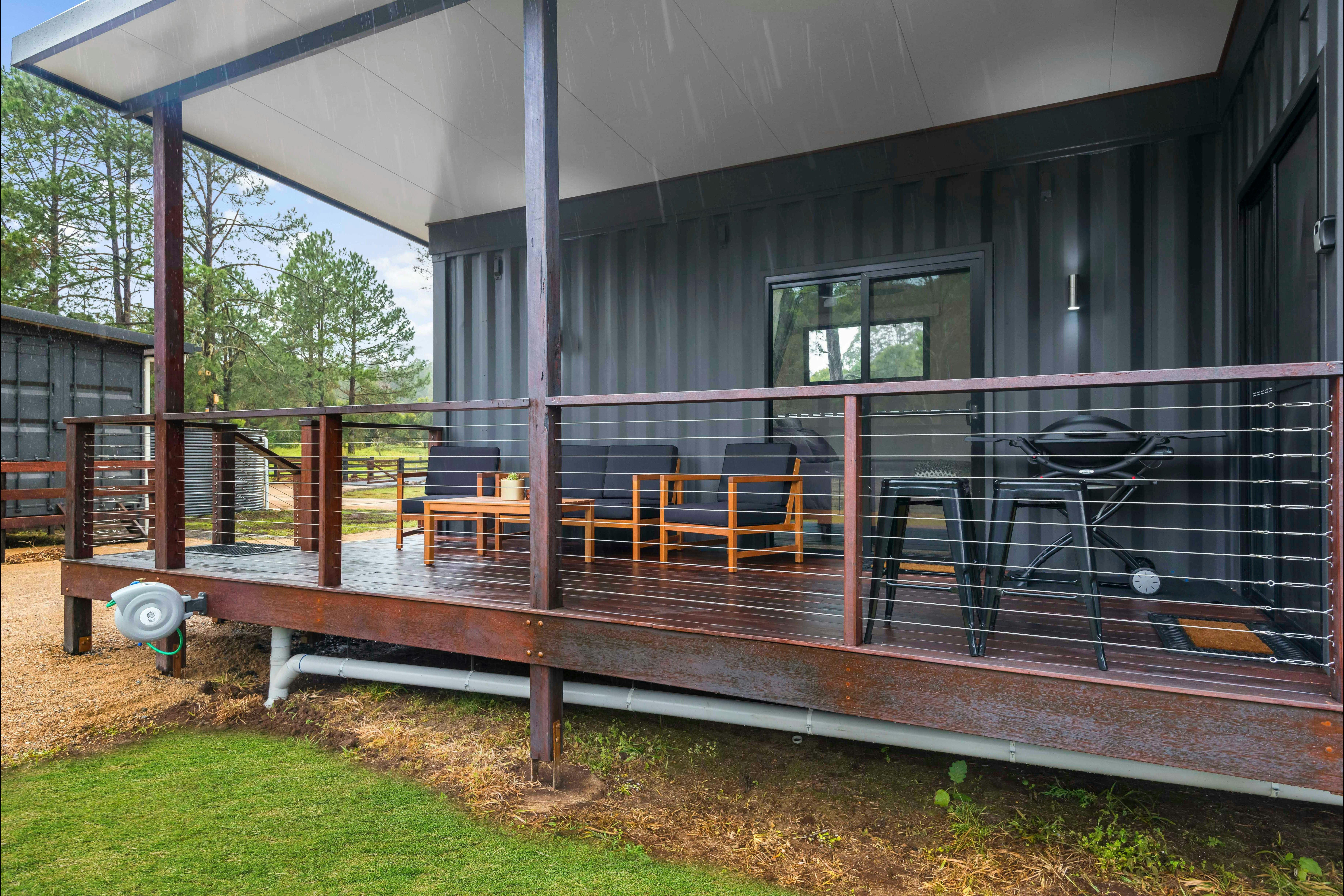 External shot showing close up of the hardwood deck, outdoor lounge and bbq