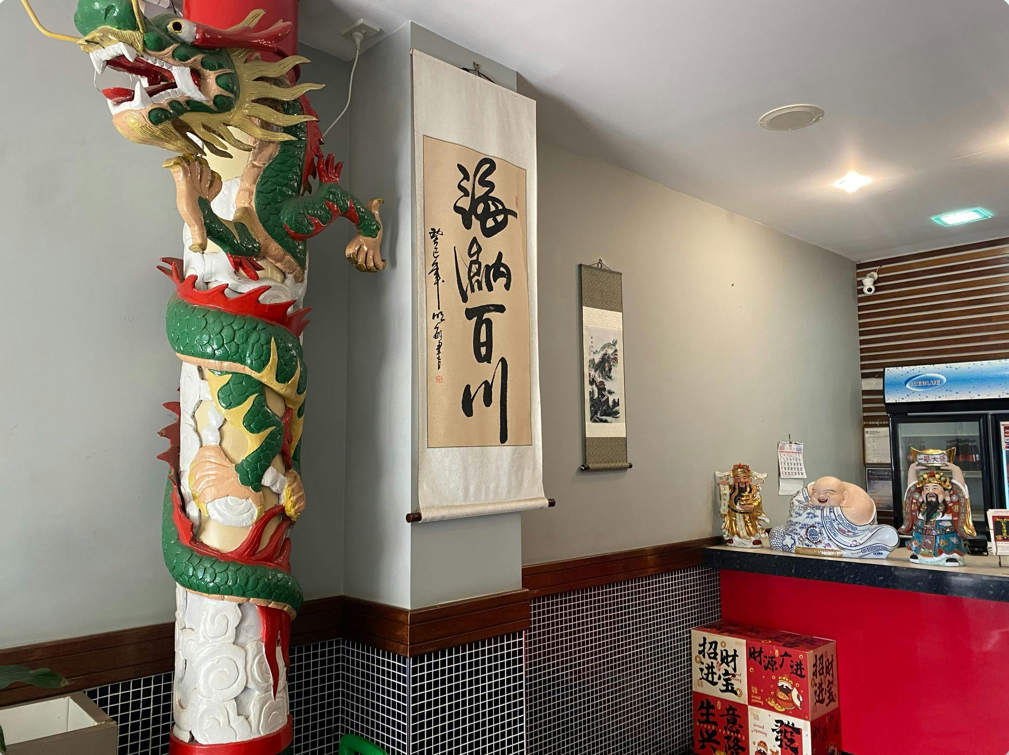 Happy Dragon Restaurant interior with a dragon statue, scrolls, and lucky decorations