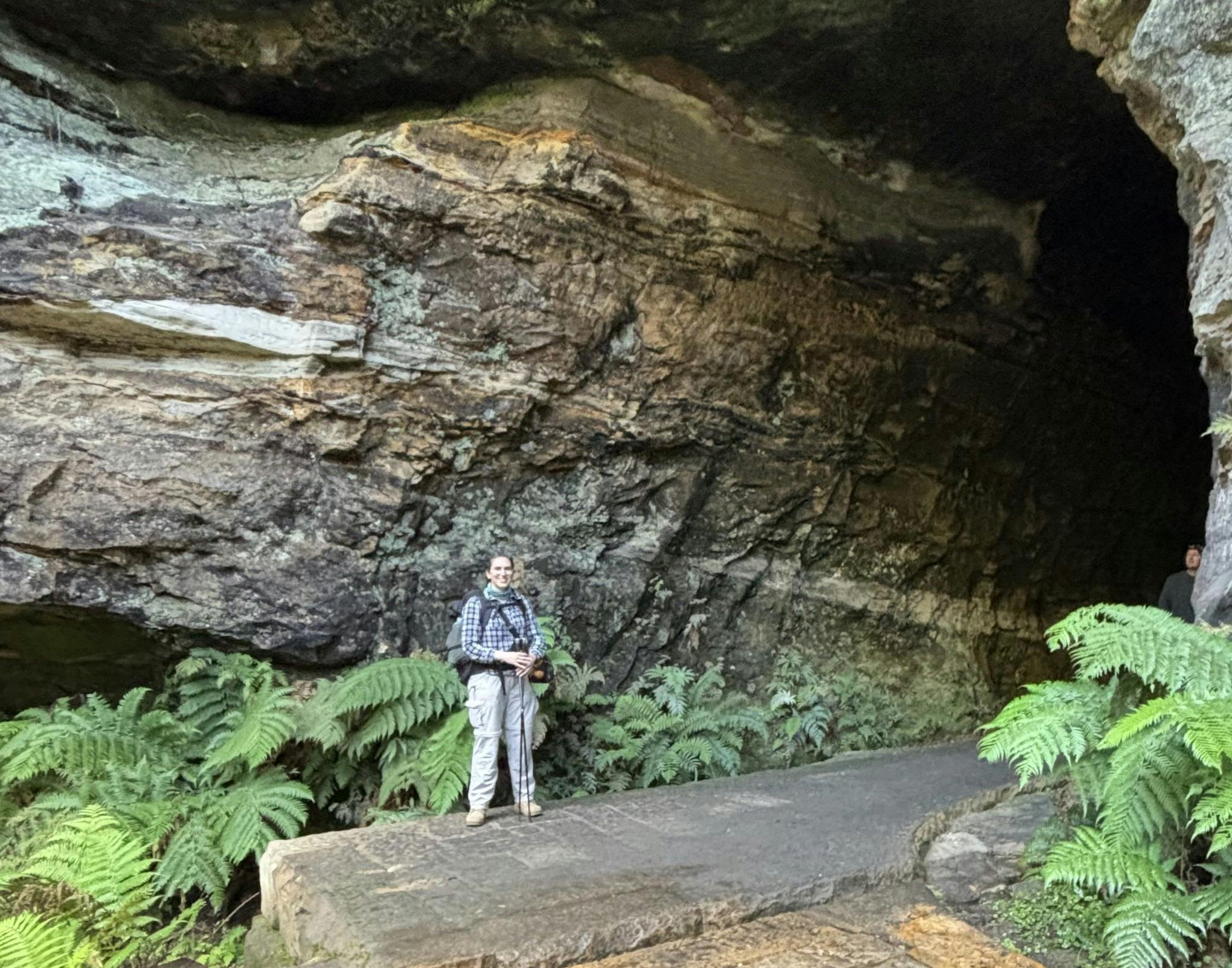 A woman standing at the entrance to a disused railway tunnel. ra