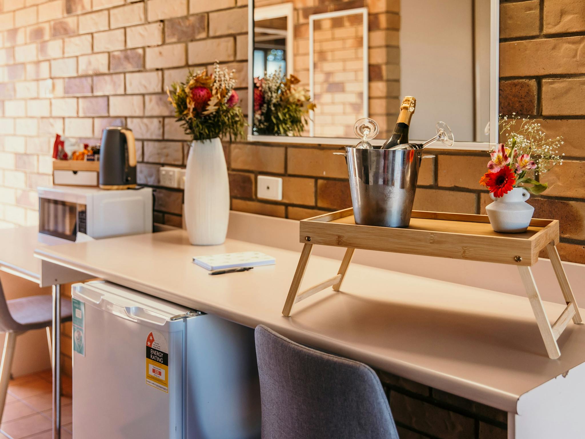 Desk, refrigerator, microwave and a tray with a champagne ice bucket. Desk, refrigerator, microwave and a tray with a champagne ice bucket.