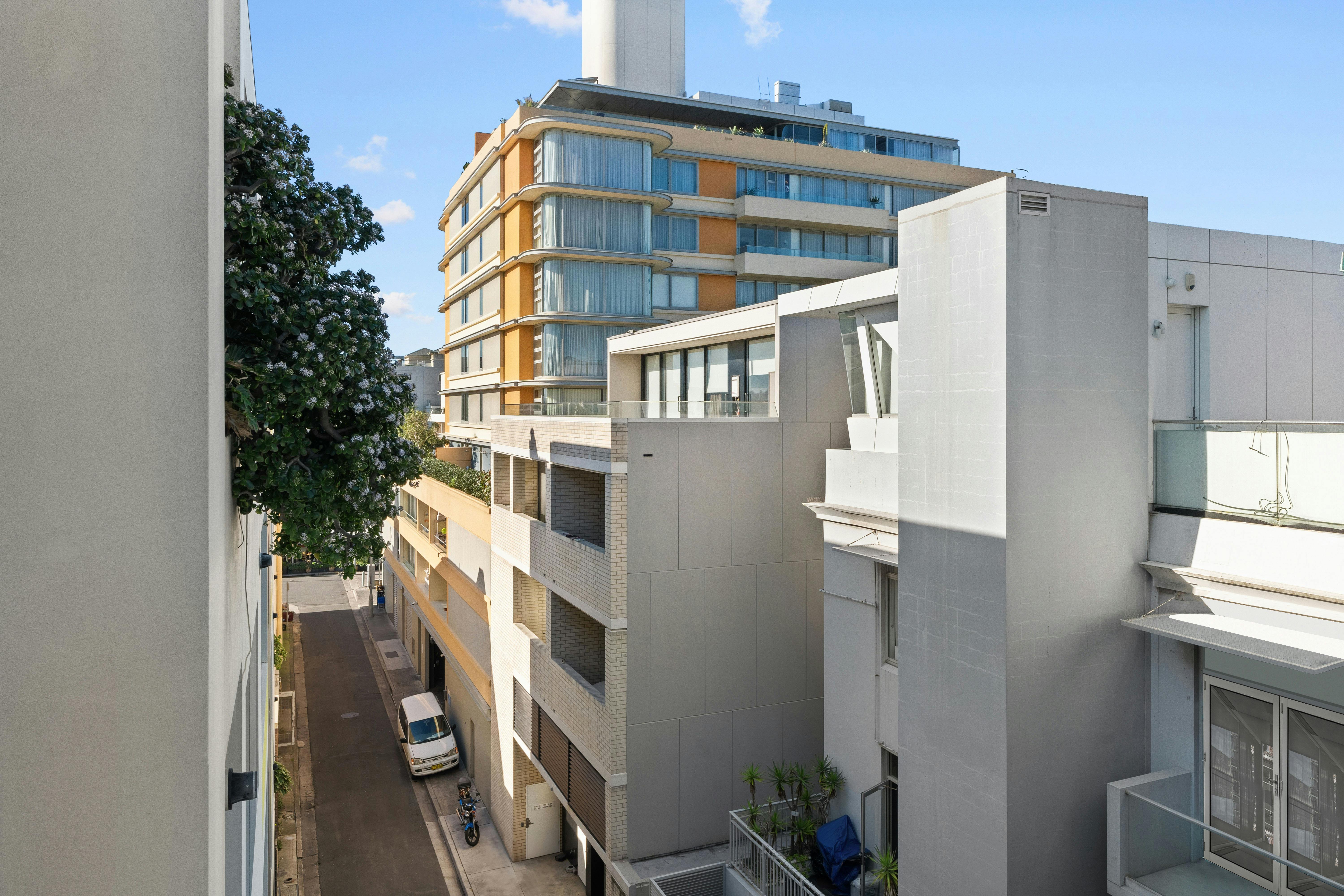 맑은 푸른 하늘과 주변을 푸르게 둘러싼 건물 외관의 풍경입니다.