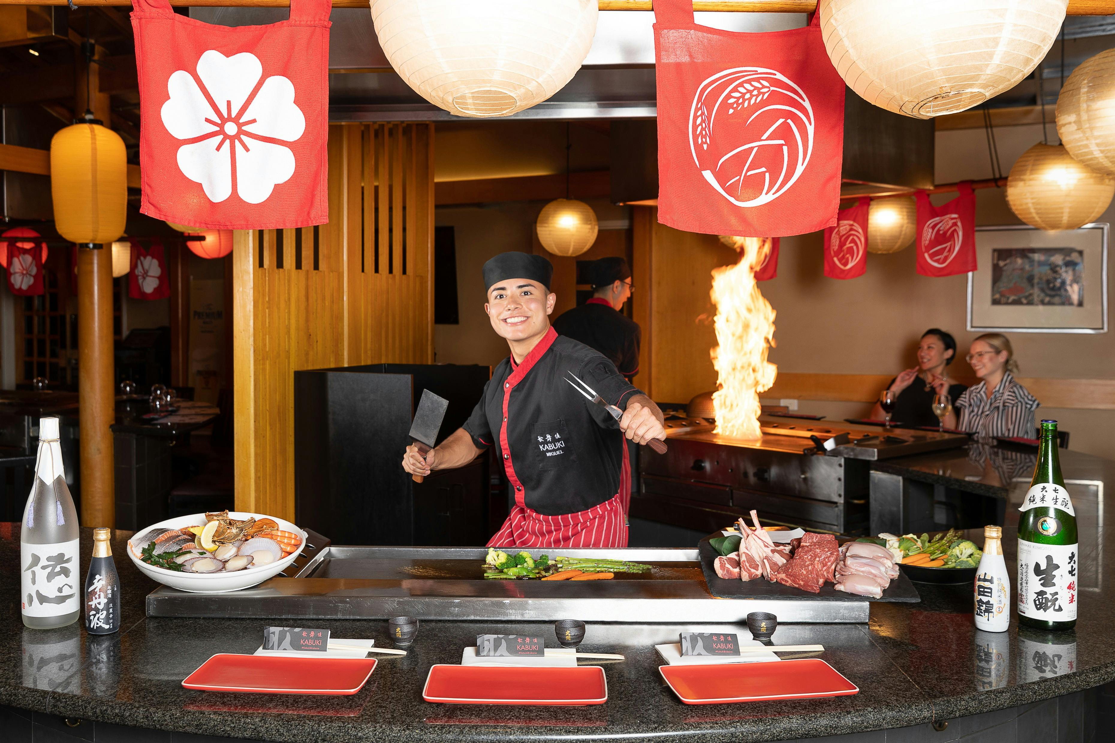 Chef behind a teppanyaki smiling at the camera