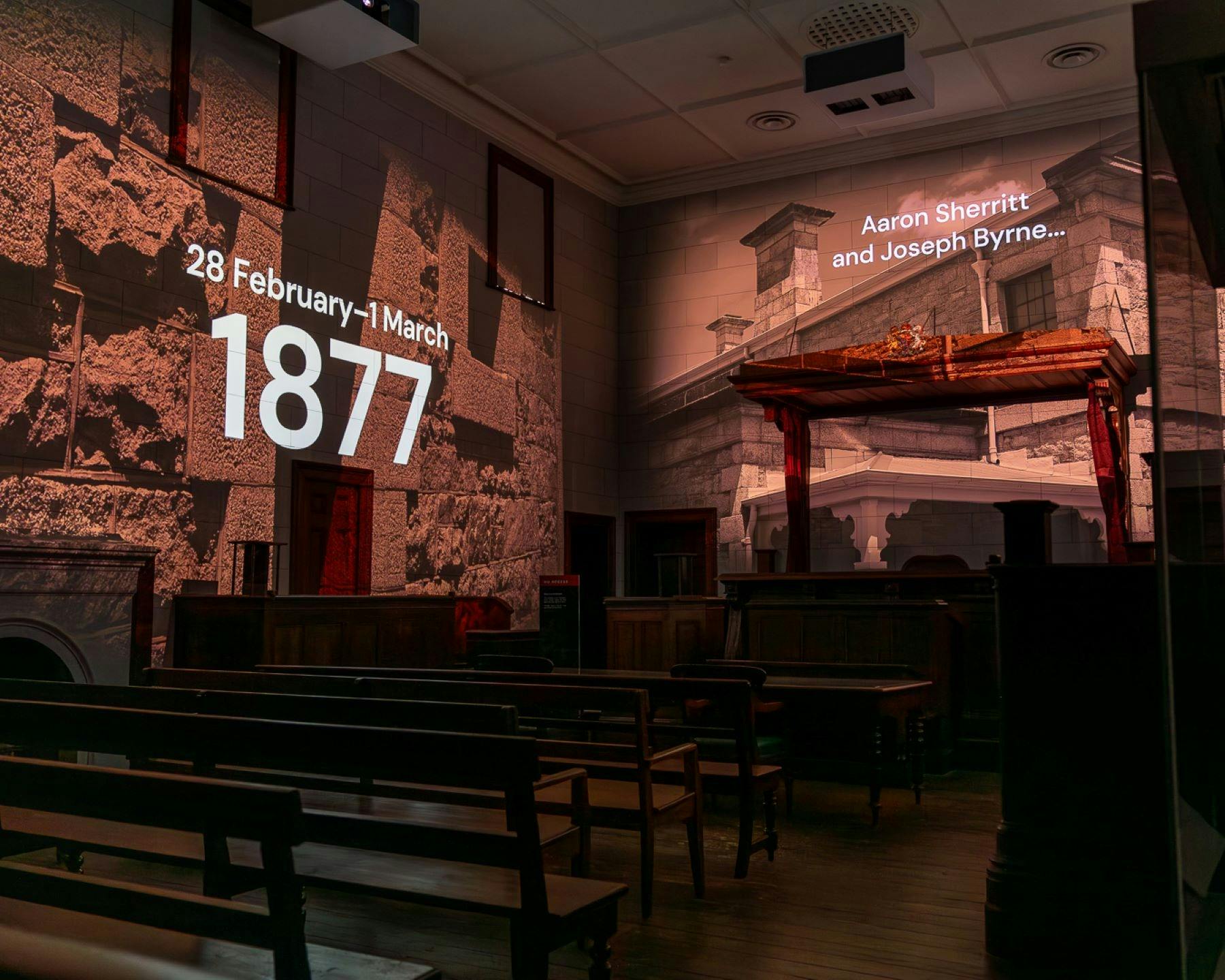 Projections of images and words cover the walls from ceiling to the roof