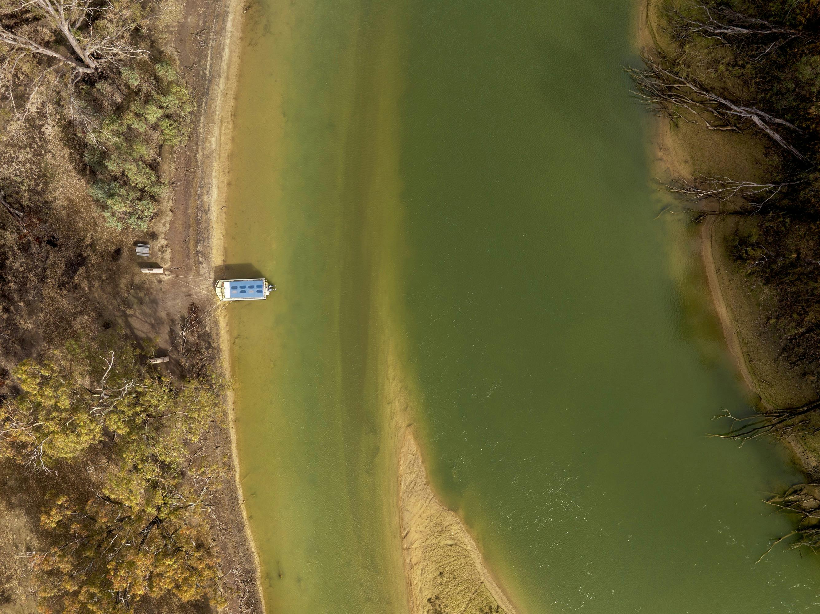 Drone view of Kingfisher boat docked by the Dhungala (Murray River) and river red gums.