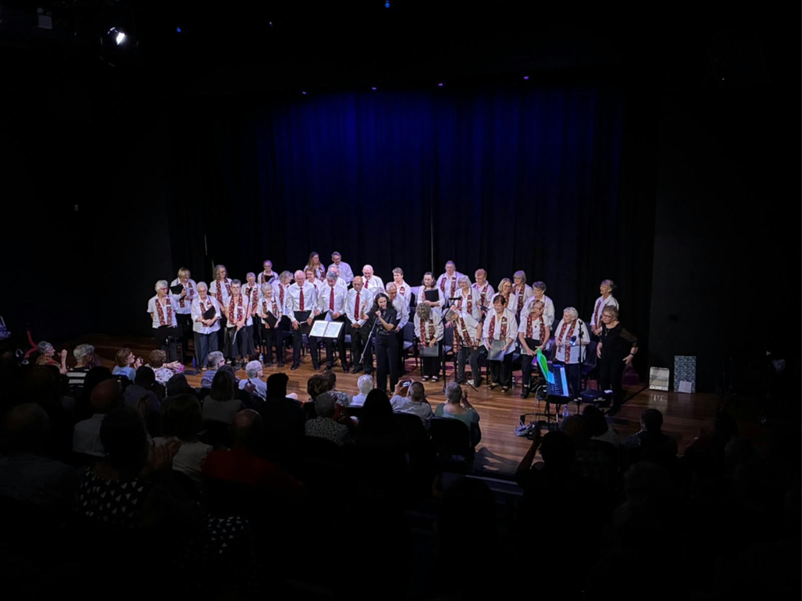 Photograph of choir group in hall with dim lighting