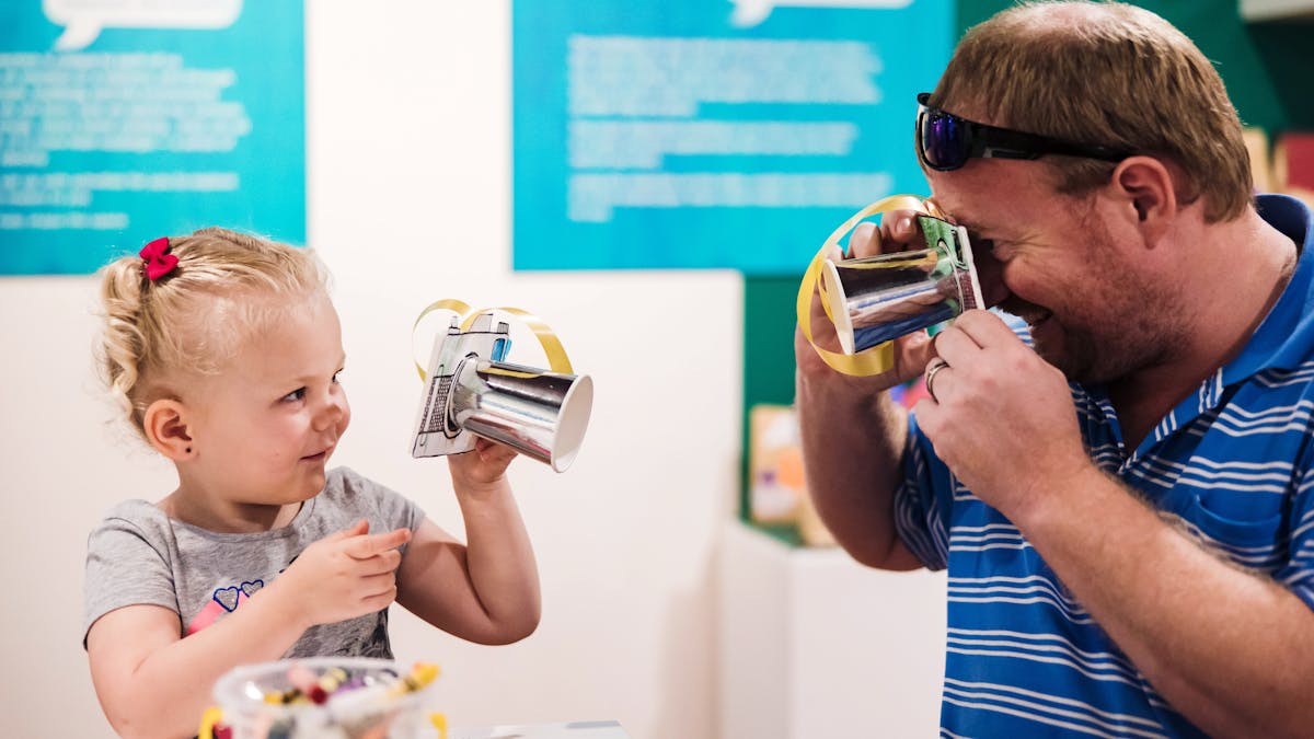 Young girl and man interact with craft items as per of the Term Time Tots program