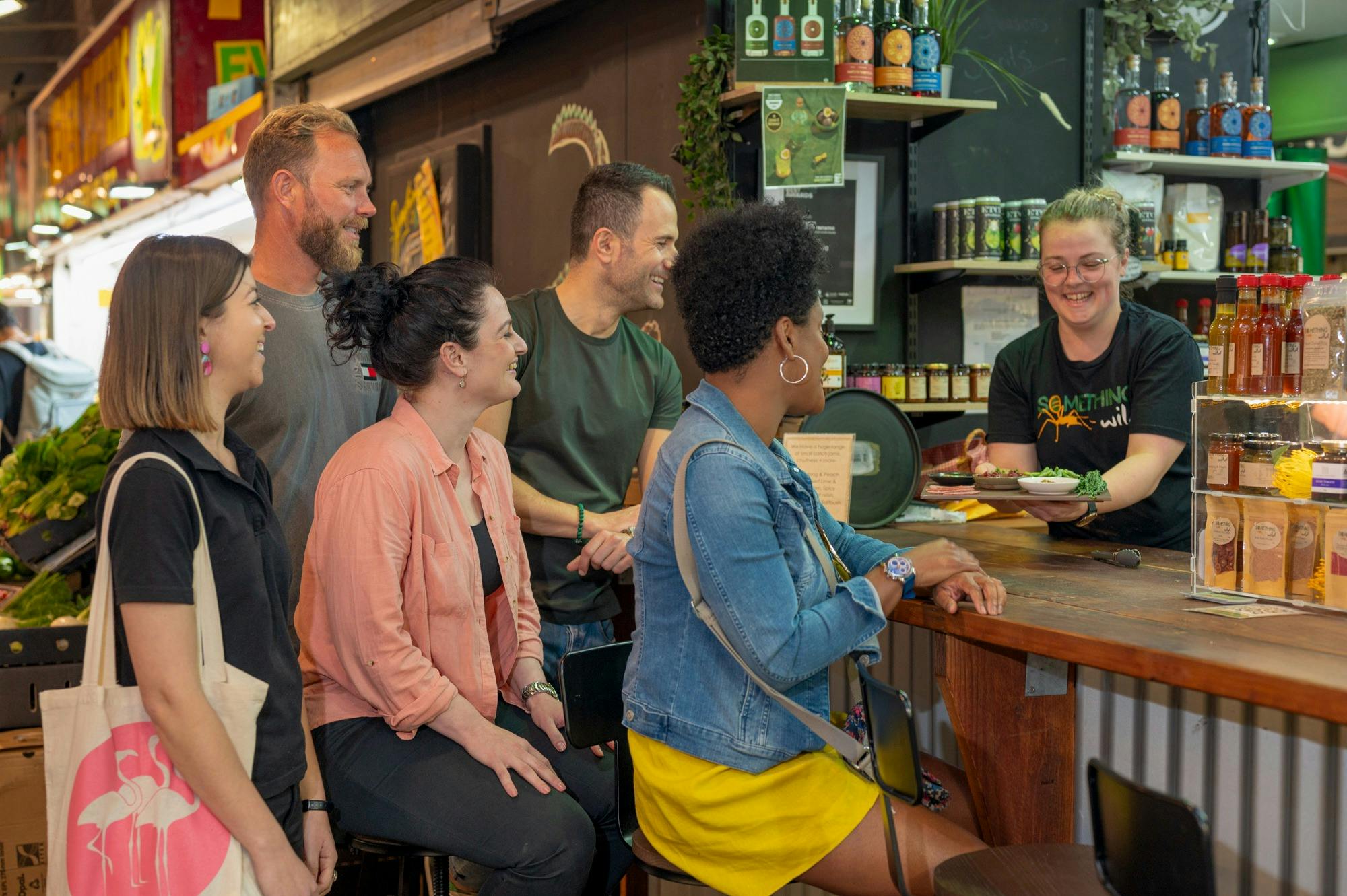 A group is being handed a native food platter at a market stall.