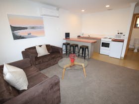 Two couches, coffee table and full kitchen in two bedroom unit