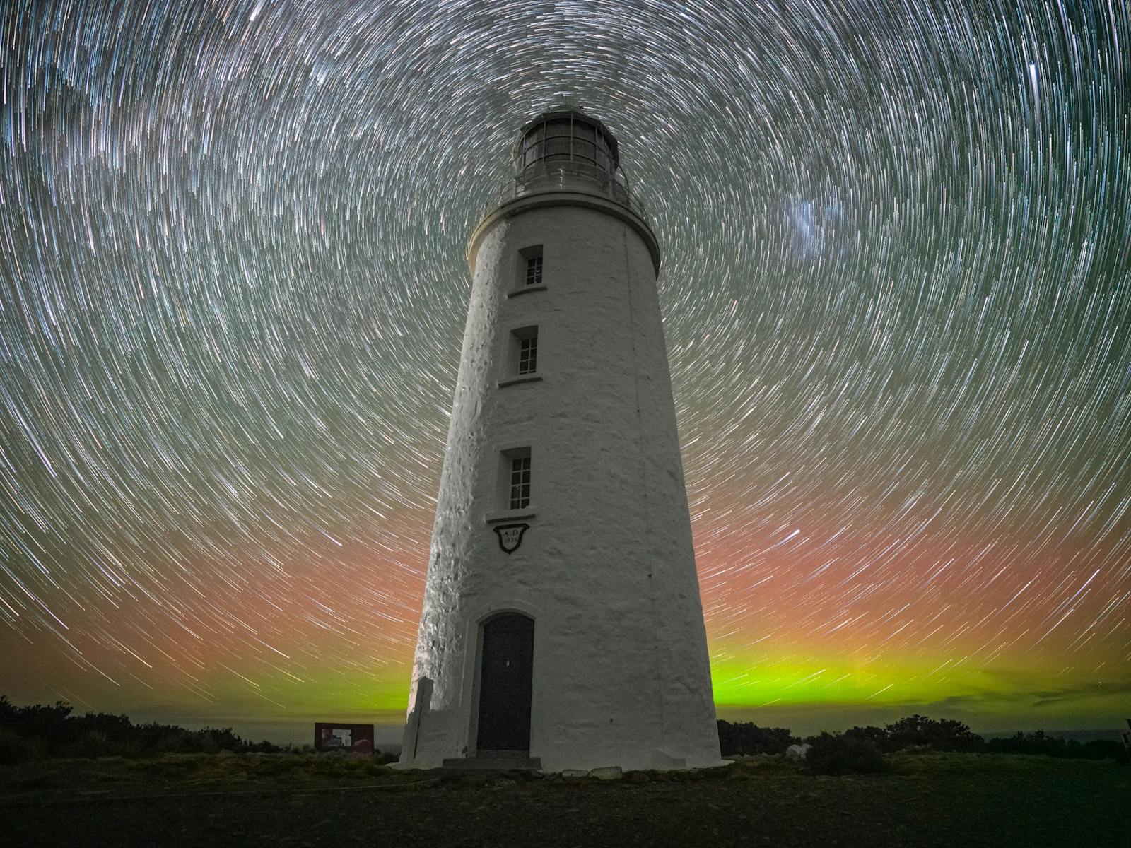 Cape Bruny Lighthouse star trail back-lit with Aurora australis