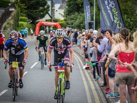 Cyclists on the course with crowd cheering