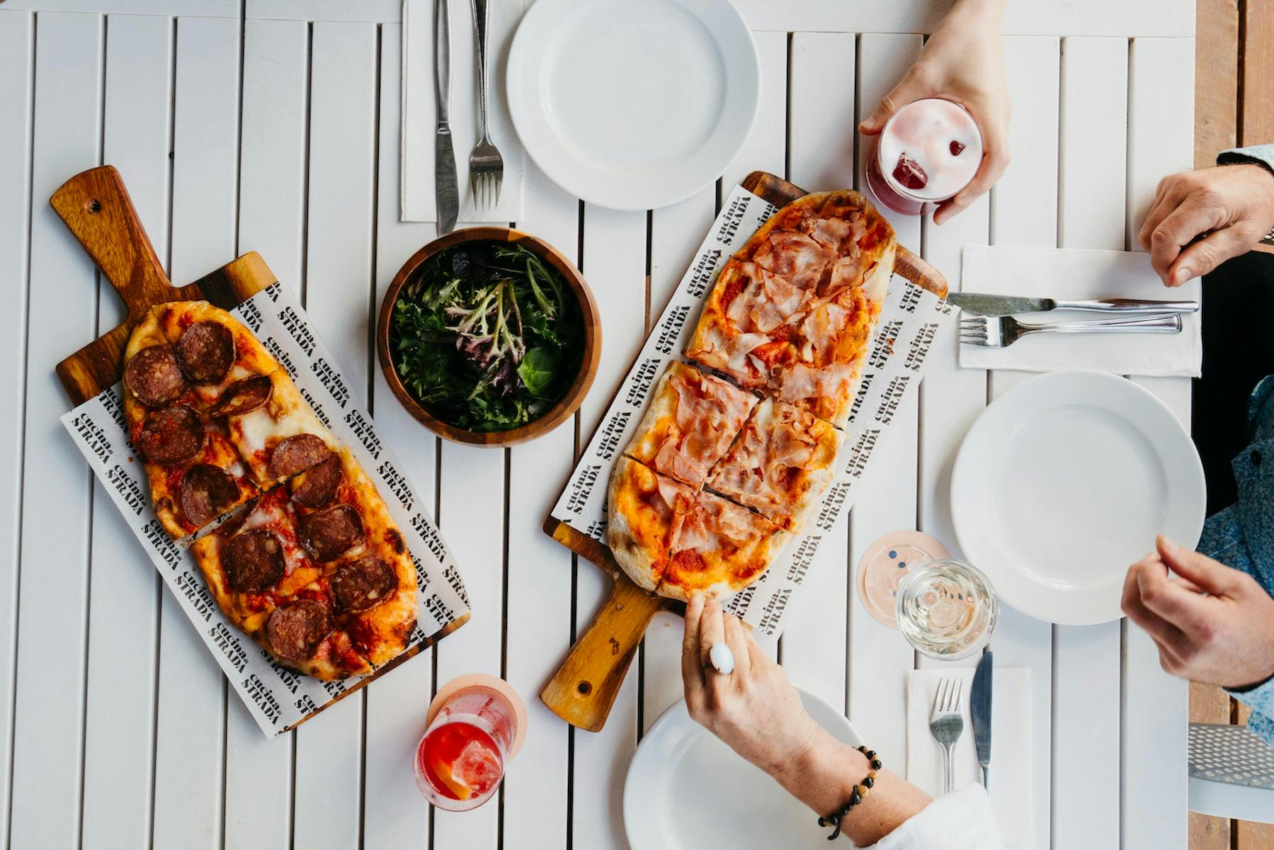 Pizzas and cocktails on while tables