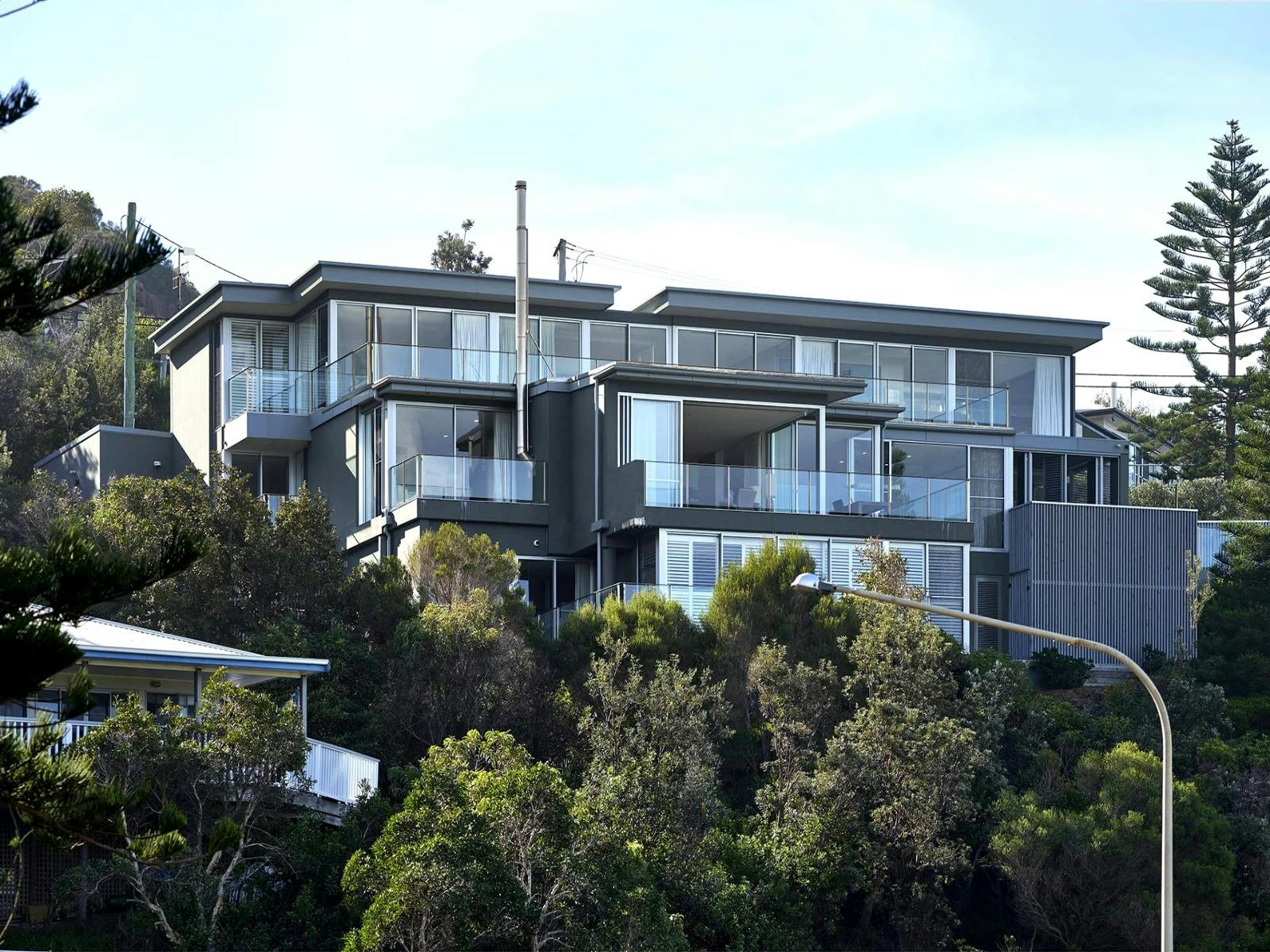 Modern three-level home with glass walls providing panoramic views