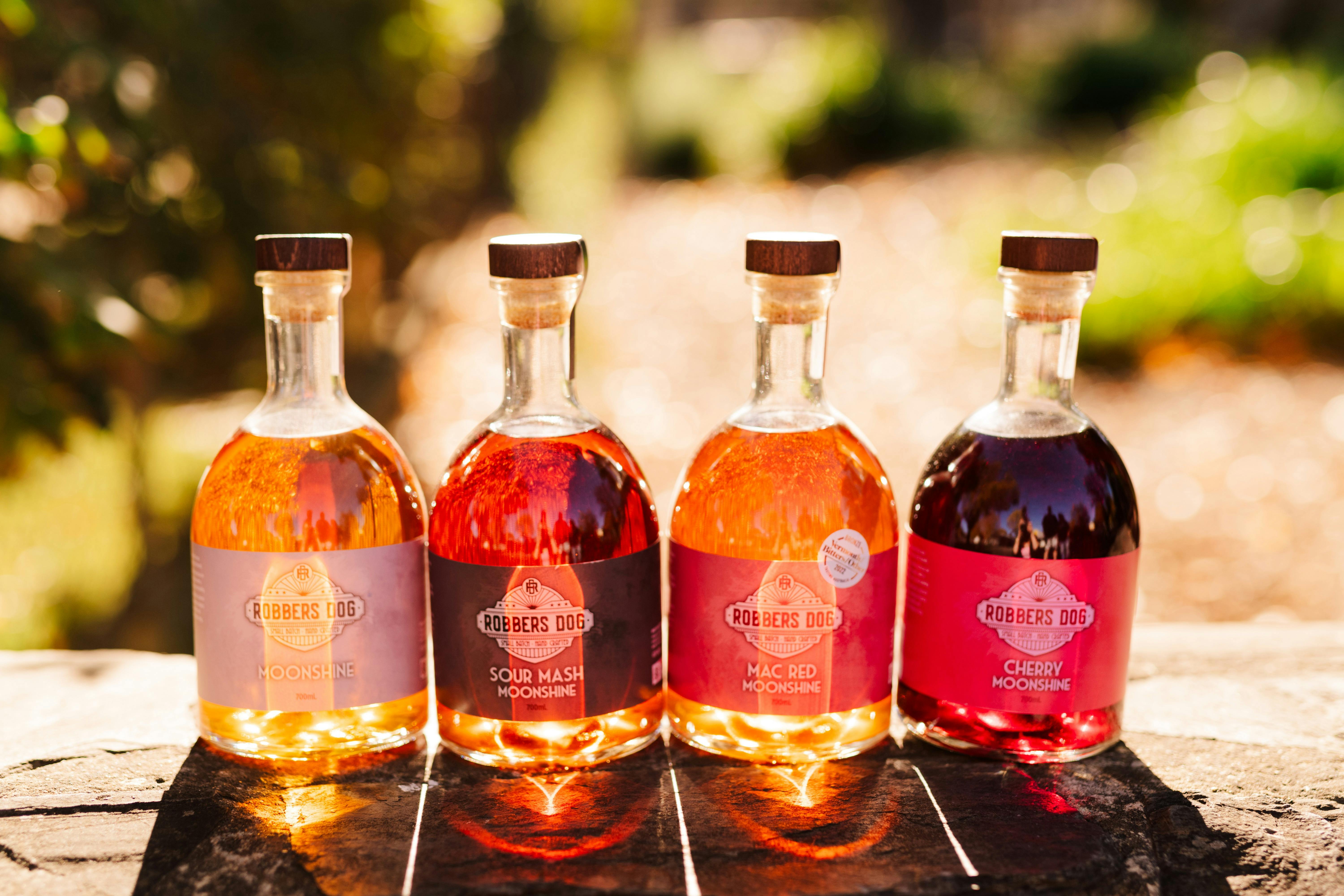 Robbers Dog Moonshine Range with the light reflecting through them to display their spirits colour