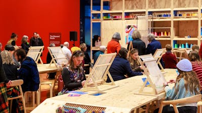 People sitting at a table weaving