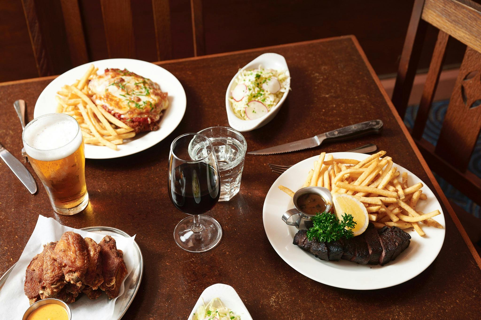 A selection of meals, including a steak and chicken wings.