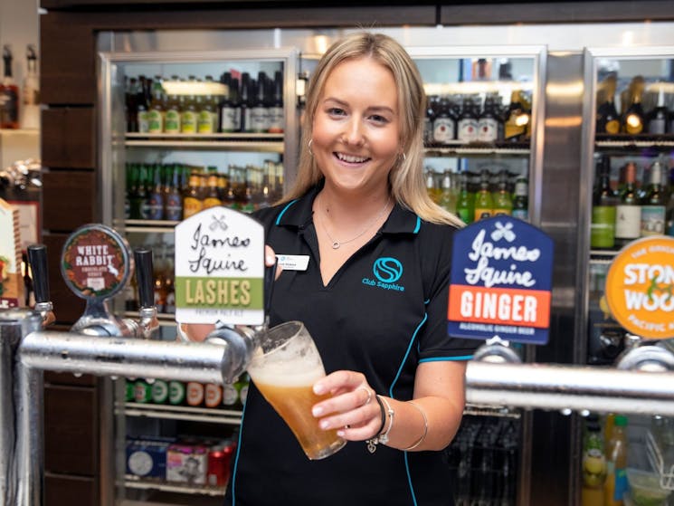 Picture of friendly bar staff pouring a beer