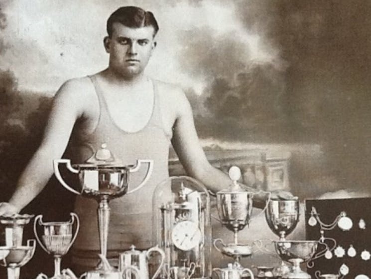 Fred Jacobs standing with table of trophies