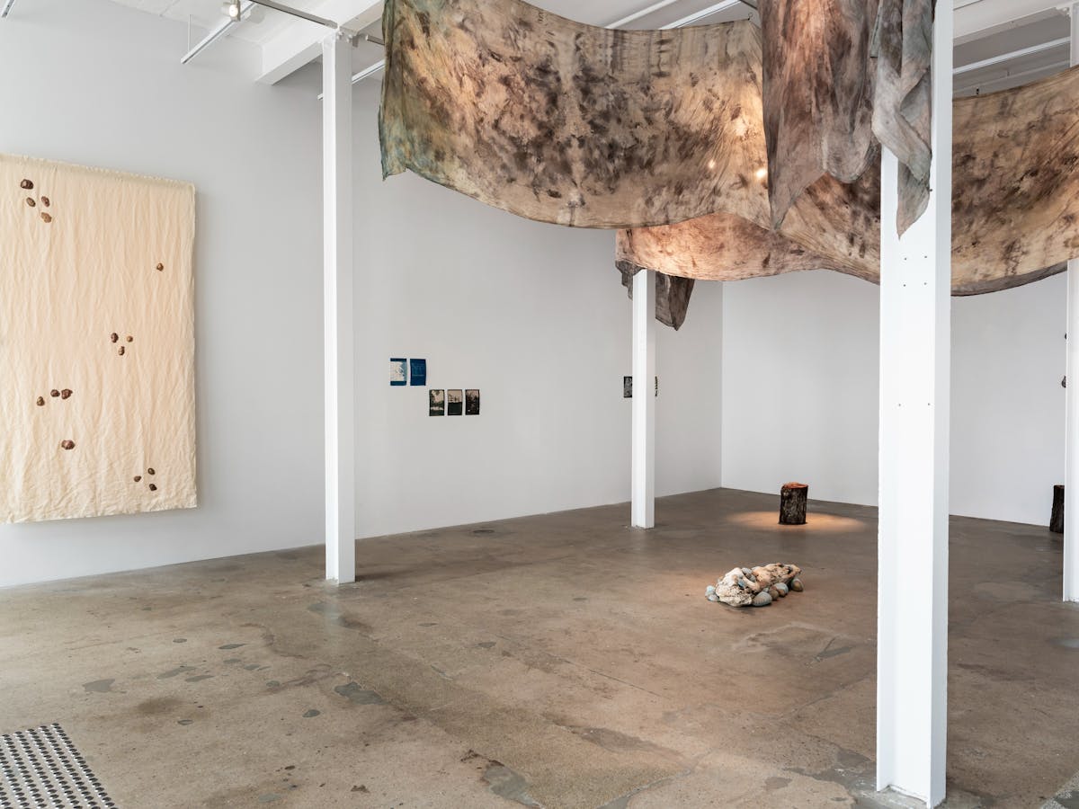 A gallery with organic fabrics, earth, rocks, cyanotype prints. A gallery with organic fabrics, earth, rocks, cyanotype prints.