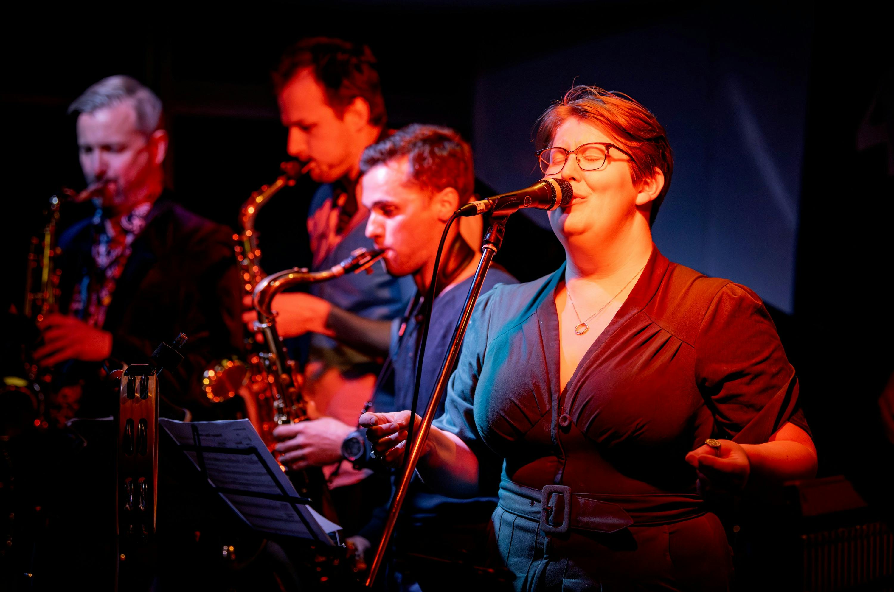 Female vocalist and sax players on stage