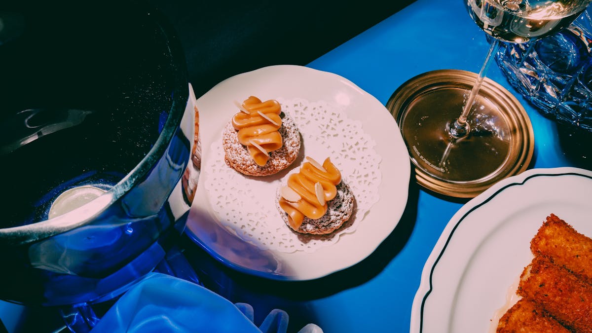 A photo of some beautiful canapes, and on a white plate and blue table
