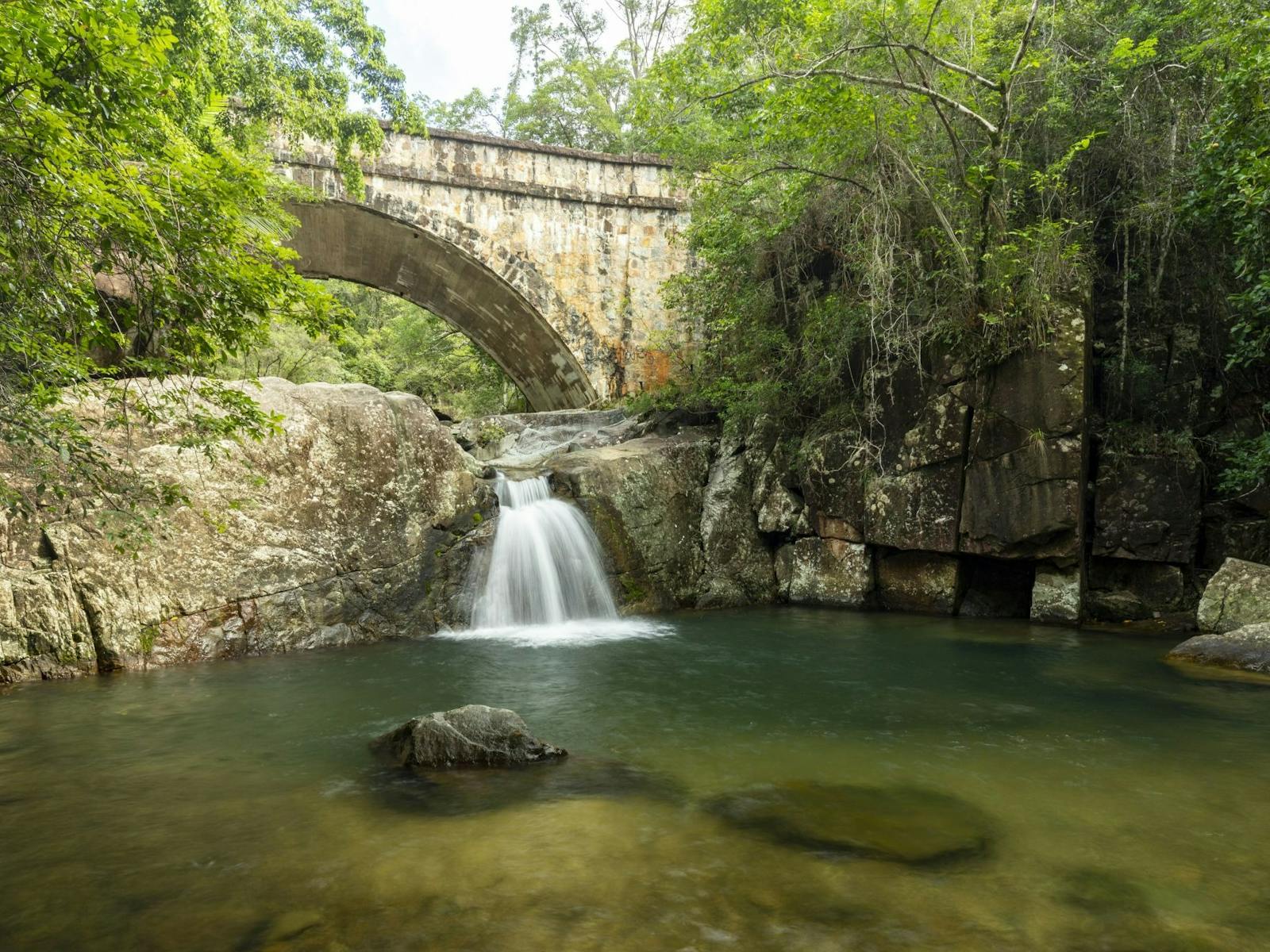 Stone bridge over a little waterfall. Stone bridge over a little waterfall.