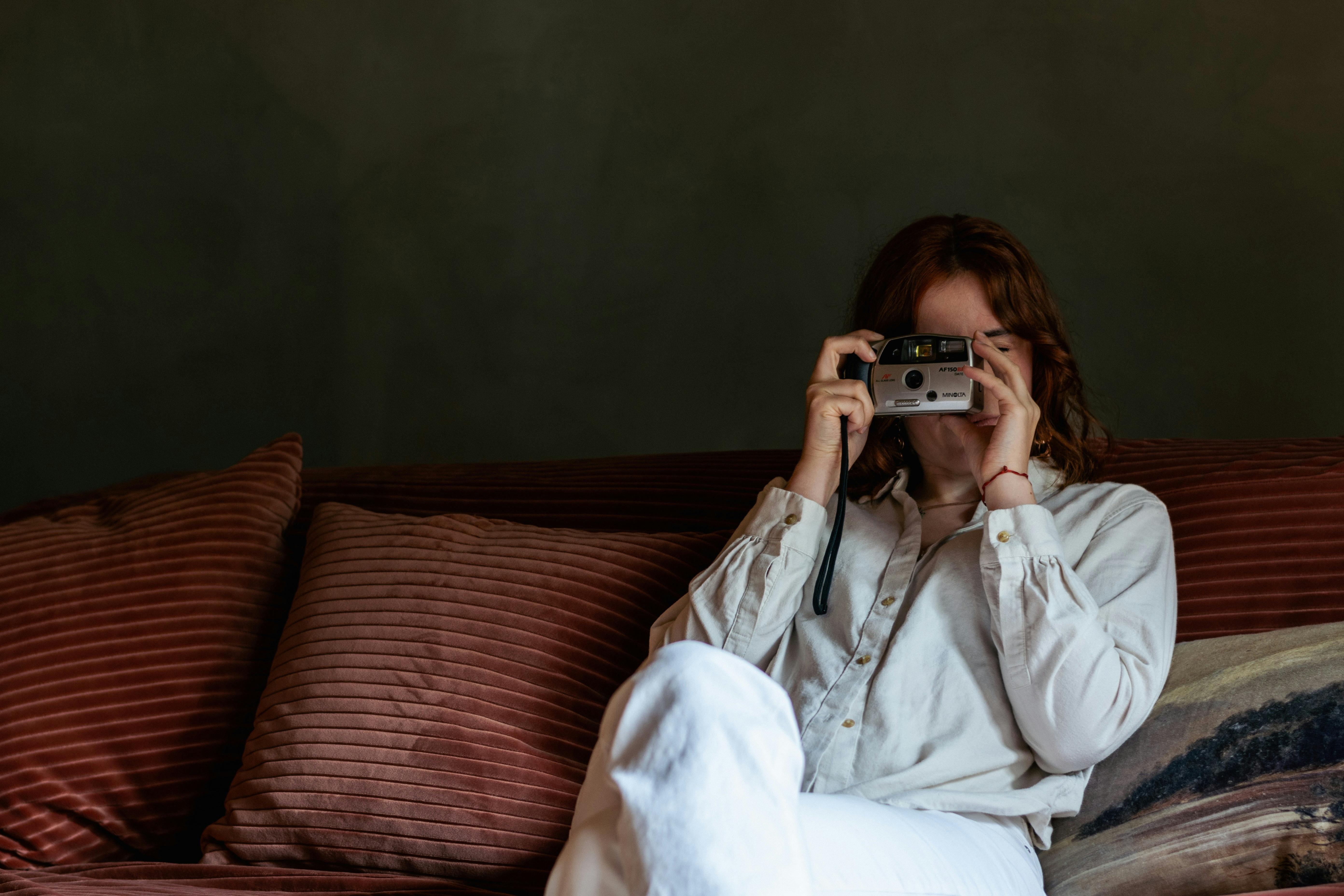 women sitting on sofa with camera