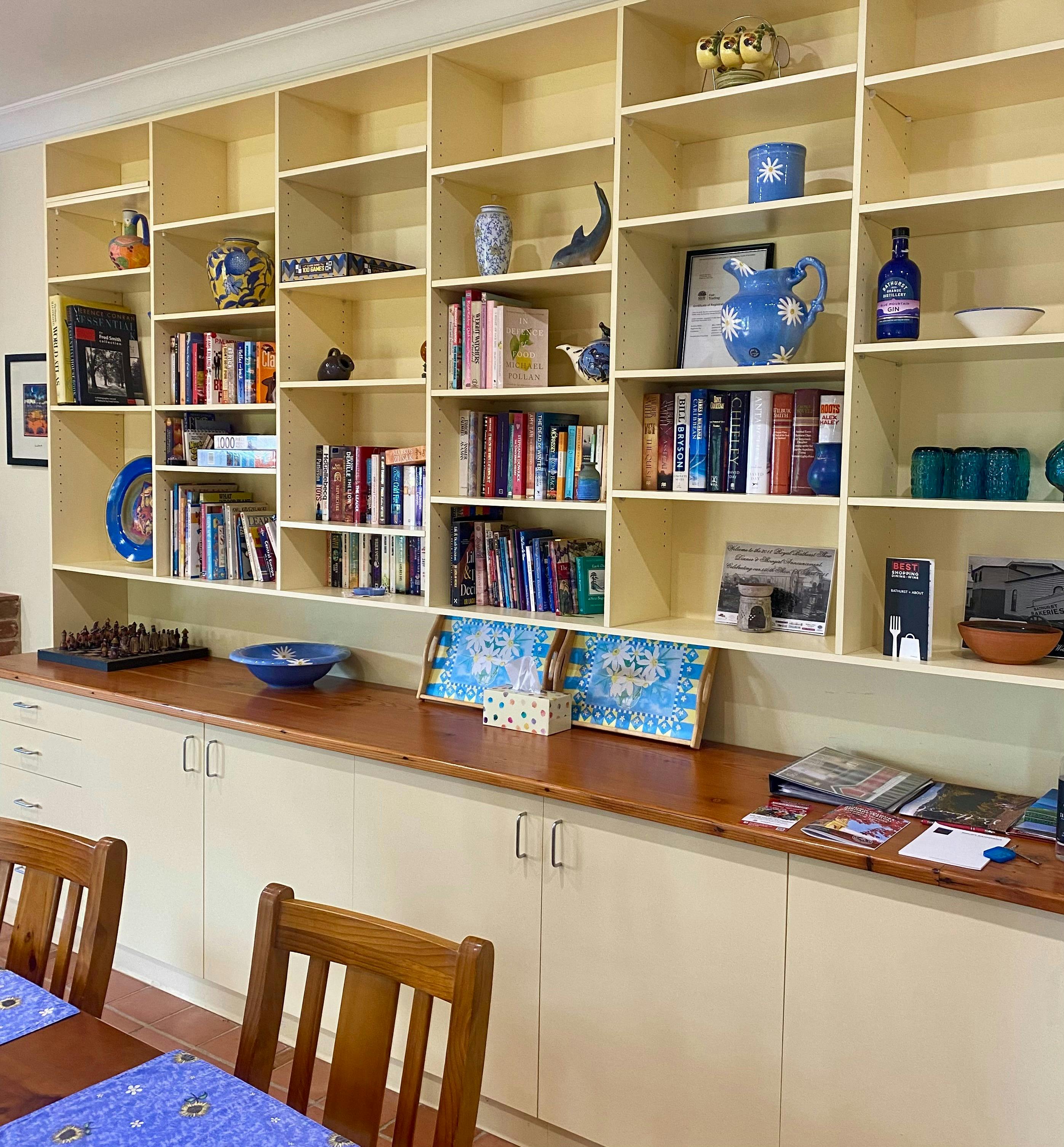 Photo is of large set of booksheves filled with books and games