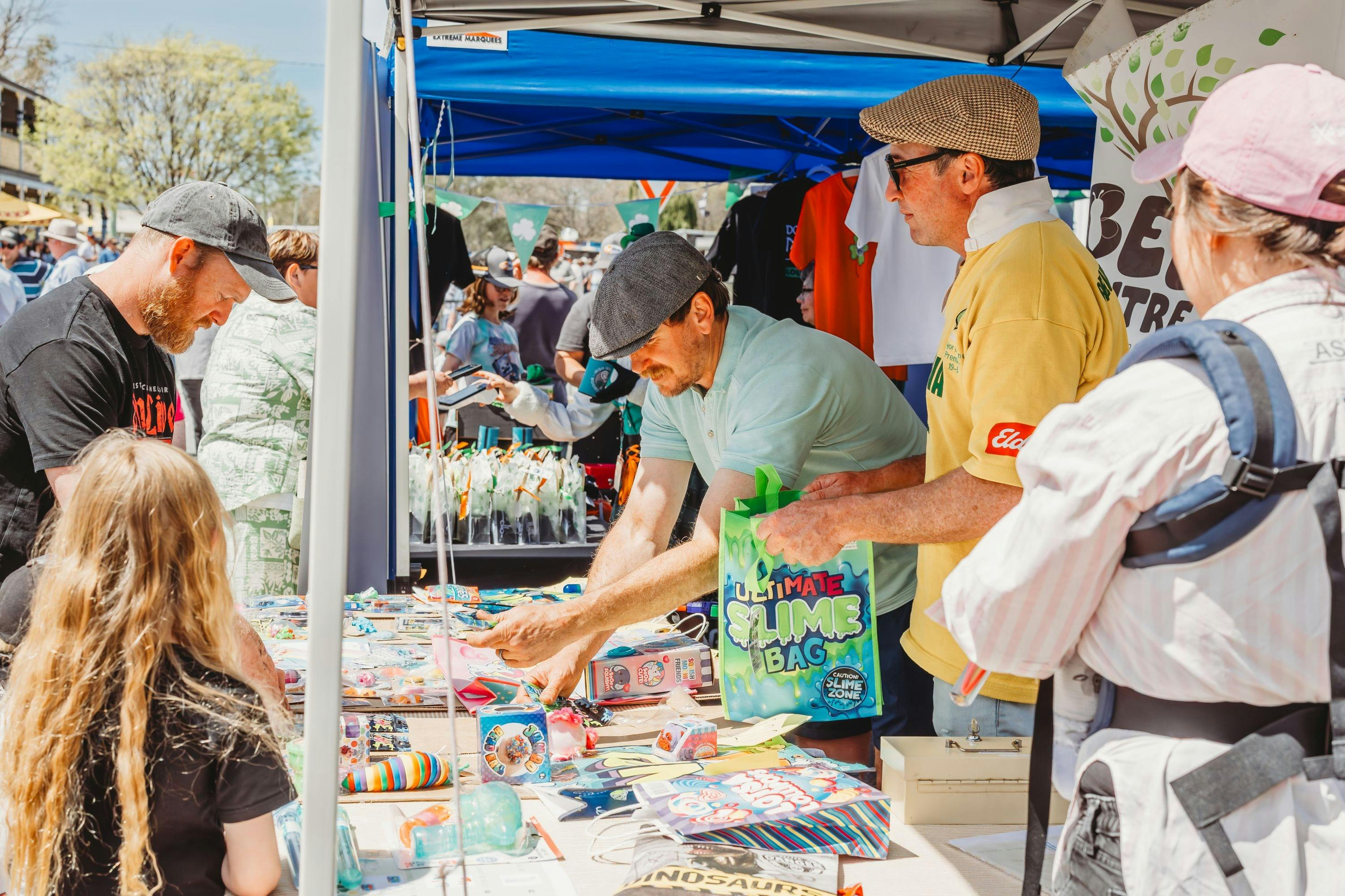 A stallholder showing his wares to customers.